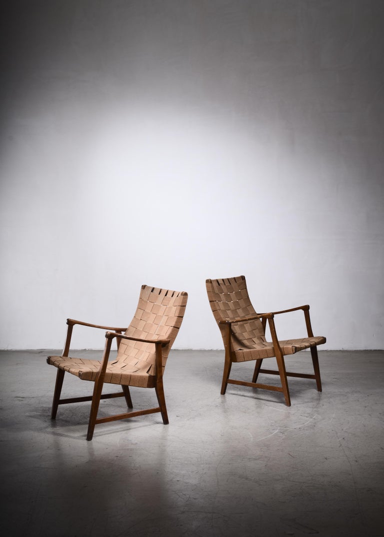 A pair of armchairs attributed to Elias Svedberg and produced by Nordiska Kompaniet. The frame is made of mahogany and has a webbed canvas seating.
One of the canvas slings has been repaired in our in-house atelier.
 