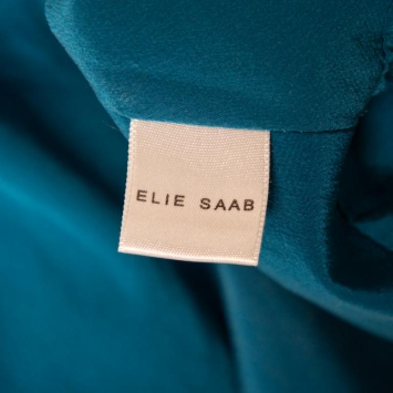 Bring Elie Saab's feminine charm and grace to your ensemble with this beautiful short dress. It is tailored using blue silk fabric and features ruched detailing and a V-shaped neckline. It is provided with a zip-type fastening. Exude sophistication
