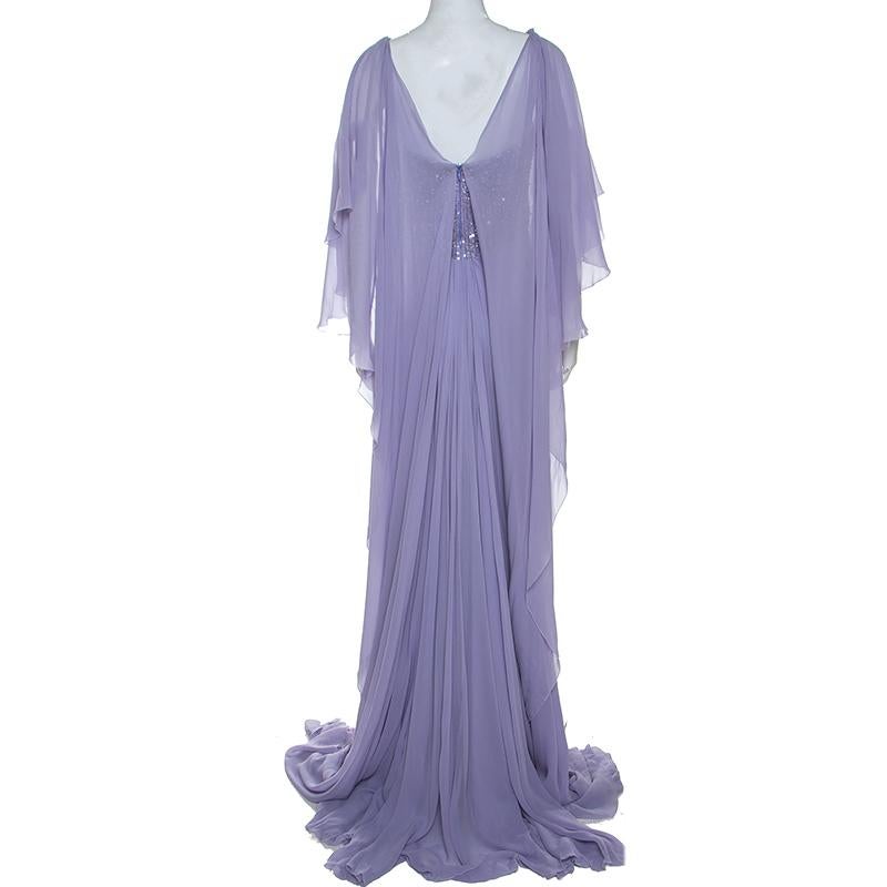 Designed for luxury, this lovely lilac gown has a flowy look with gathered detailing and a floor-length hemline. The cape sleeves add to the feminity of this gown. Wear this statement piece with minimal accessories and glitzy