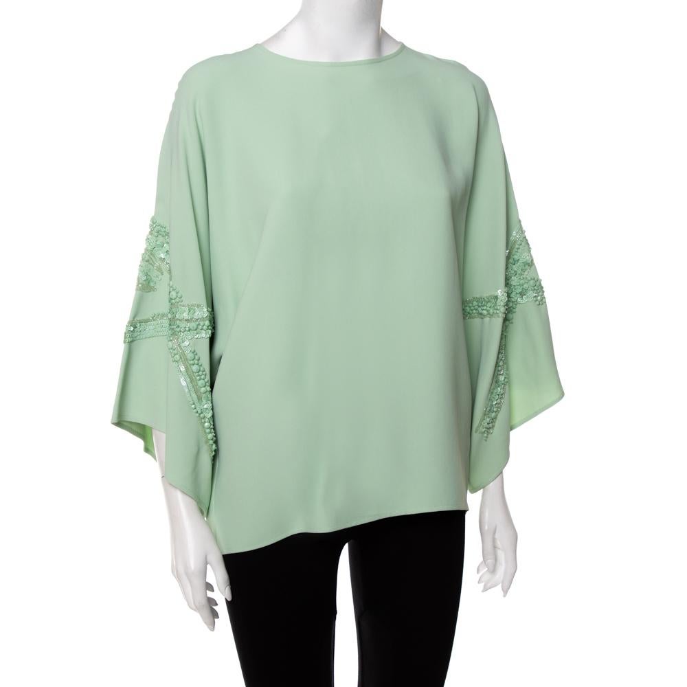 This designer top by Elie Saab skillfully merges elegant tailoring and statement detailing with a simple silhouette. The women's top in mint green has wide sleeves, a round neckline, and matching embellished details. The creation is secured by a