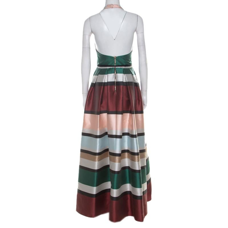 Elie Saab design their elegant evening wears with subtle hints of glamour. This multicoloured, ball gown features a lovely striped design all over, a belted waistline, twin pockets and a full-length bottom. It is styled in a halter neck style and a