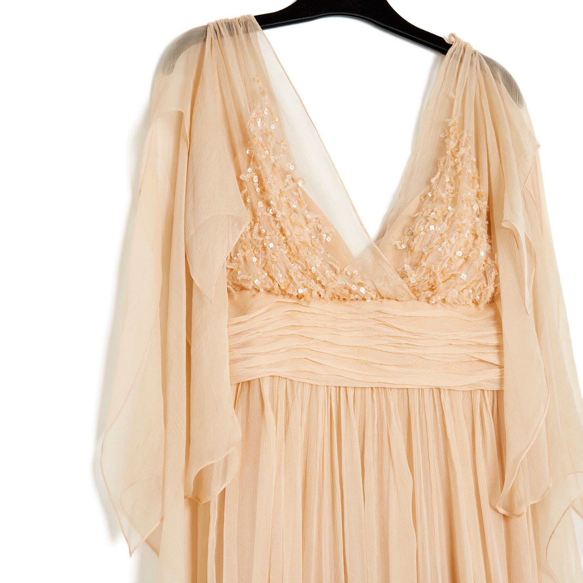 Vestido Elie Saab de gasa de seda rosa albaricoque pálido, tirantes finos y hombros cubiertos con velo, pedrería en el pecho, cintura imperio drapeada (bajo el busto), falda larga con quillas y largos asimétricos, forro de crepé de seda a juego