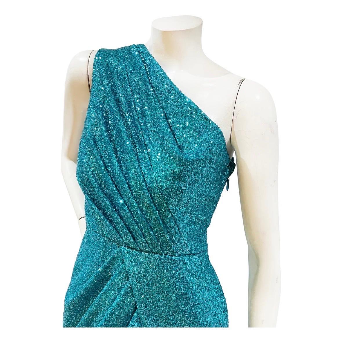 Sequin gown by Elie Saab
Made in Lebanon
One shoulder 
Turquoise sequins throughout 
Decorative asymmetrical pleating through bust and waist 
Shoulder sash that hangs freely on back 
Side zipper and hook closure 
Floor length 
Fabric: 100% polyester