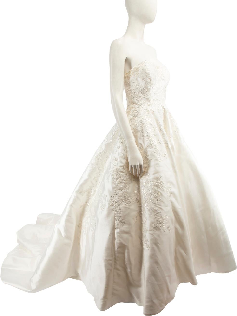 CONDITION is Good. General wear to dress is evident. There is a pull to the weave at the back near the centre zip and on the right side of the body on the lace applique. There is overall discolouration and marks in the lining, the net lining , hem,