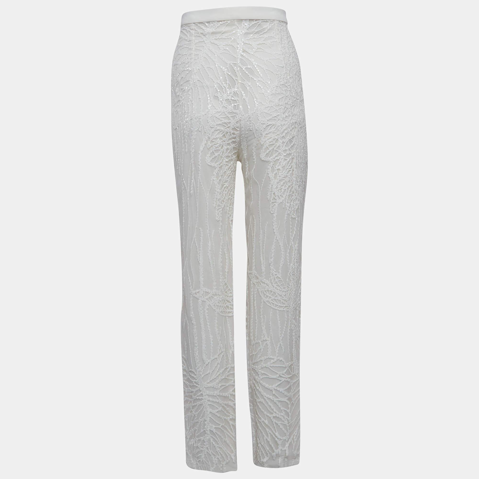Adorn yourself in the ethereal charm of Elie Saabs trousers. Crafted with meticulous attention to detail these trousers exude timeless glamour. Delicate sequin embroidery dances across the tulle fabric creating a mesmerizing effect that captivates
