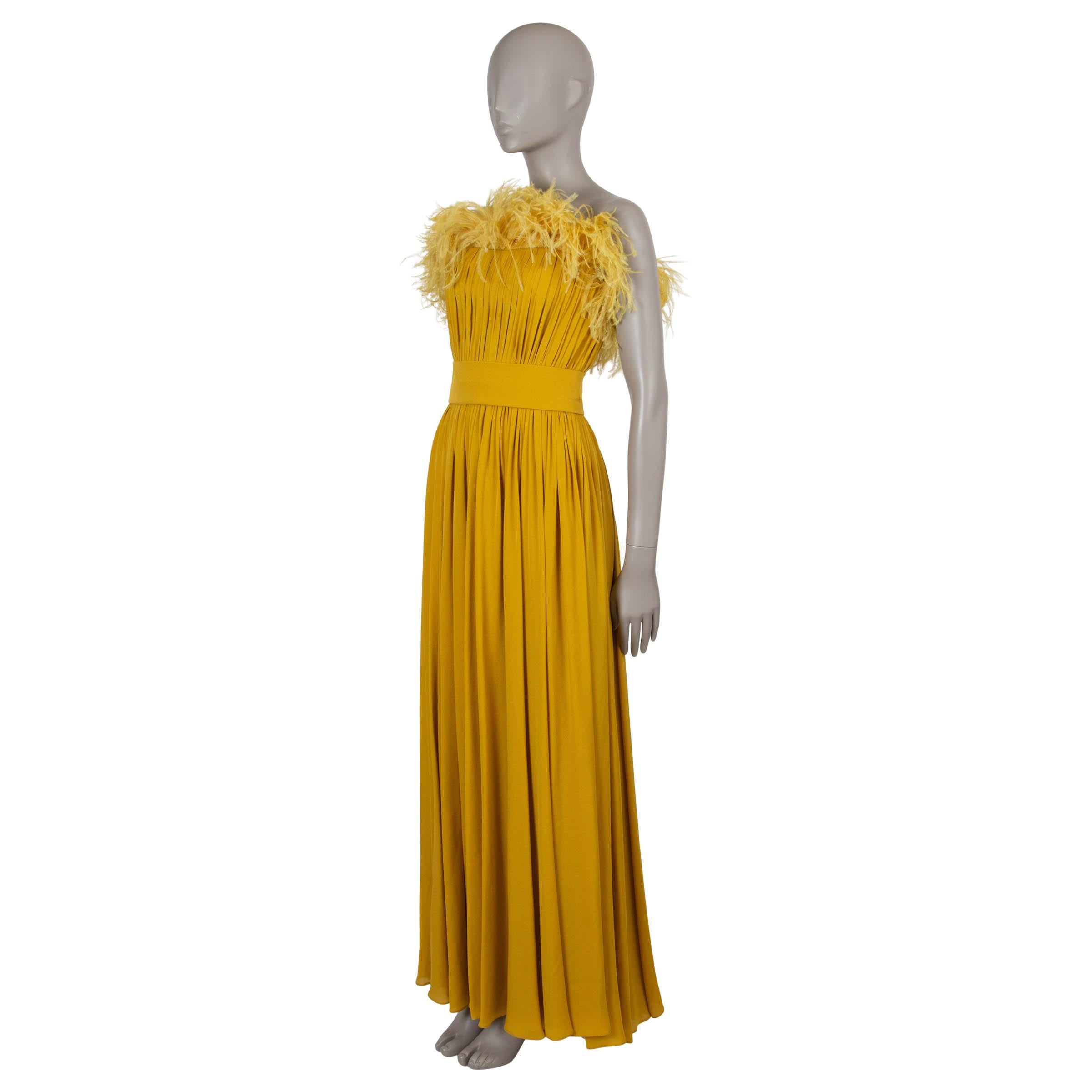 This 100% authentic Elie Saab gown in yellow silk exudes elegance and timeless sophistication. The strapless design features a fit-and-flare silhouette with an ostrich feather-trimmed, pleated top, a draped maxi skirt, and a wide waistband that