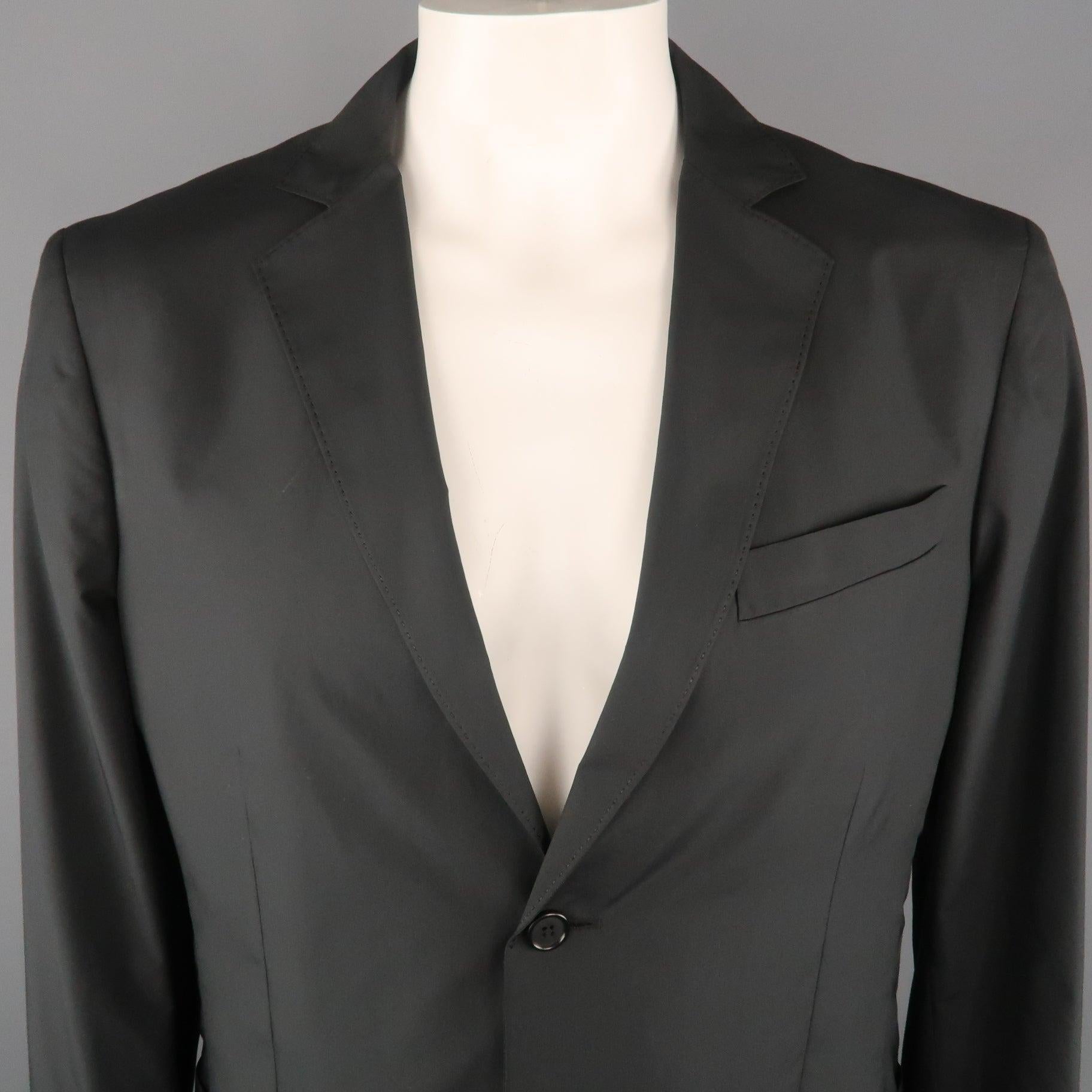 ELIE TAHARI Jacket comes in a black tone in a solid polyester material, with a notch lapel, slit and patch pockets, 2 buttons at closure, single breasted, buttoned cuffs, and a single vent at back. Excellent 
Pre-Owned Condition. 

Marked:   US 44