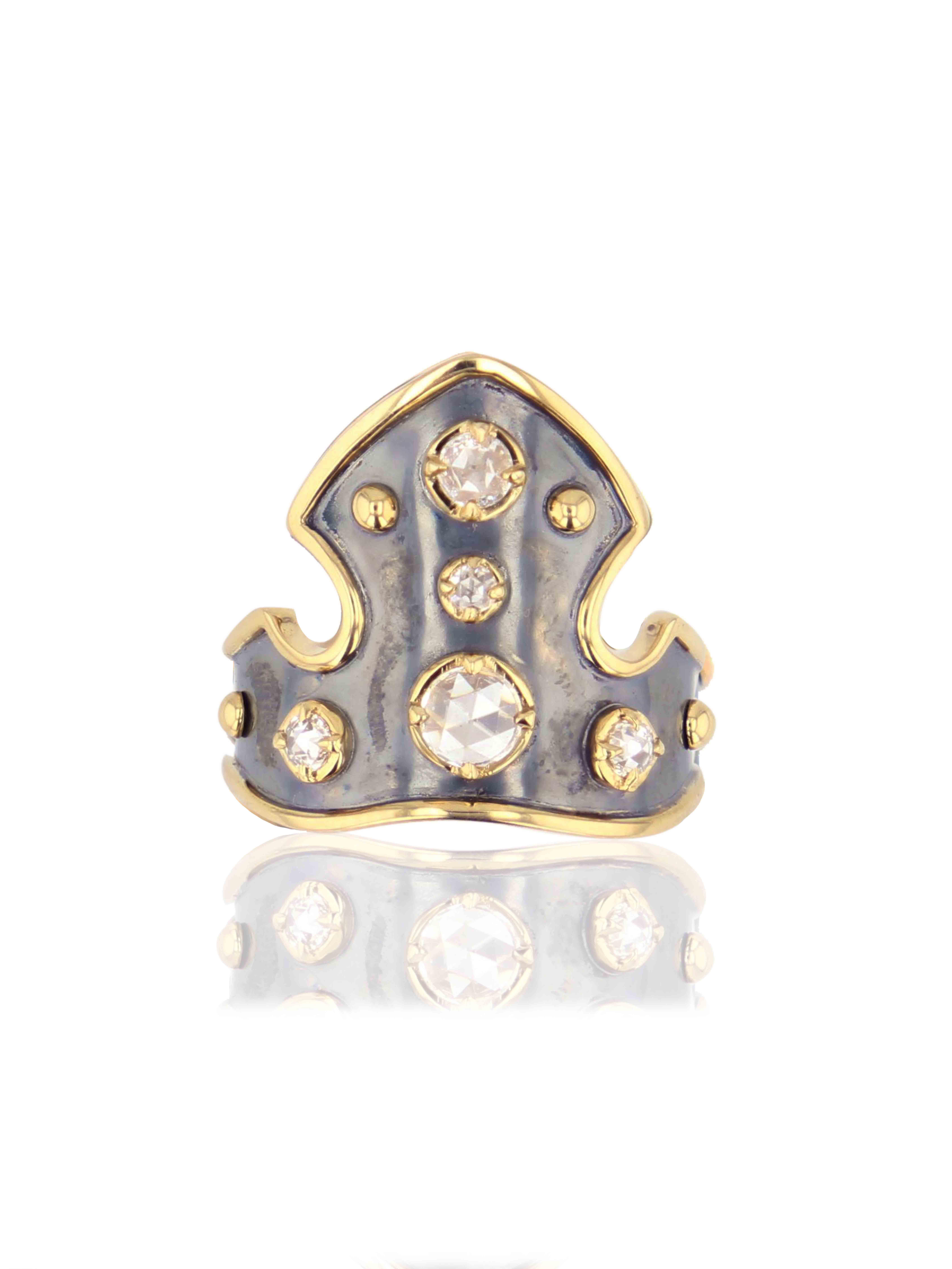 Patined silver blazon-shaped ring rail whose contours and claws are in yellow gold. It is set with with 5 diamonds and 7 yellow gold spikes. Inside the ring is a polished silver floral pattern in relief.

Corps de bague en forme de blason en argent