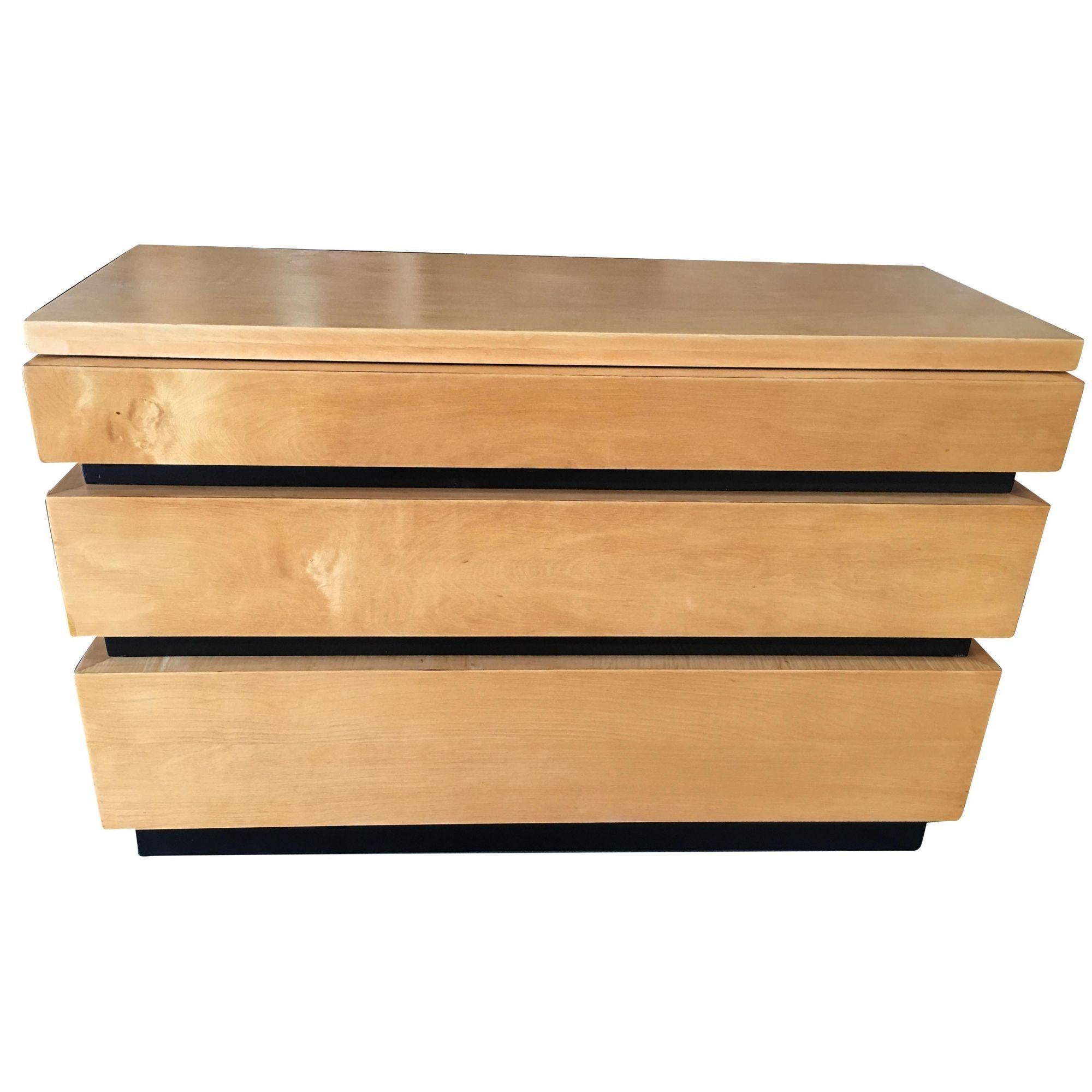 Commode basse de style moderne inspiré par Eliel Saarinen, avec une teinte foncée et une façade de tiroir enveloppante unique. Un excellent exemple de la période de transition entre l'Art déco et le Mid Century,

Circa 1940.