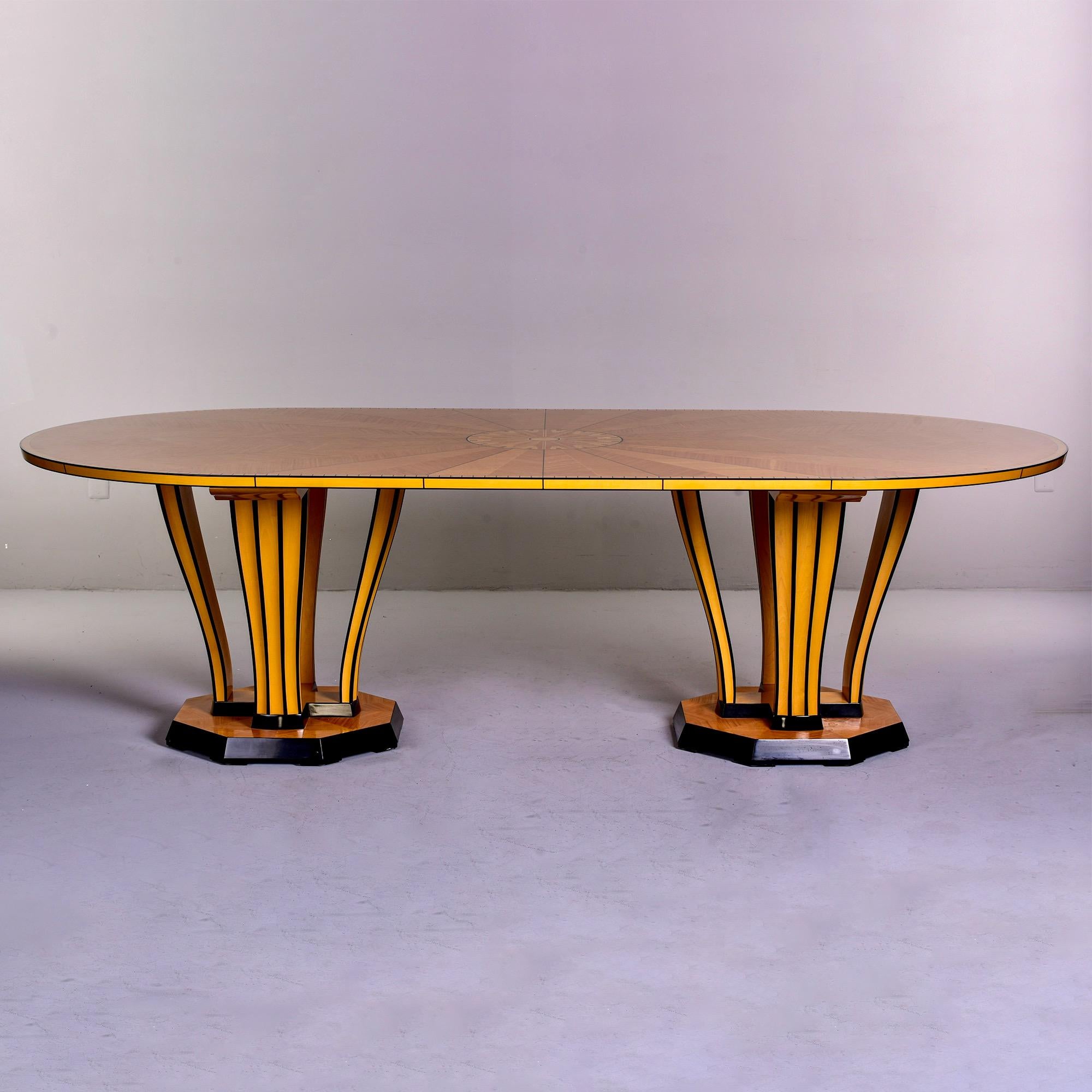 Manufactured by Charles Phipps & Sons in 1990, this is a licensed production of Eliel Saarinen's circa 1929 design. This large oval table has a double pedestal base with a dramatic sunburst inlay pattern. Made of maple with limba, ramin and ebonised