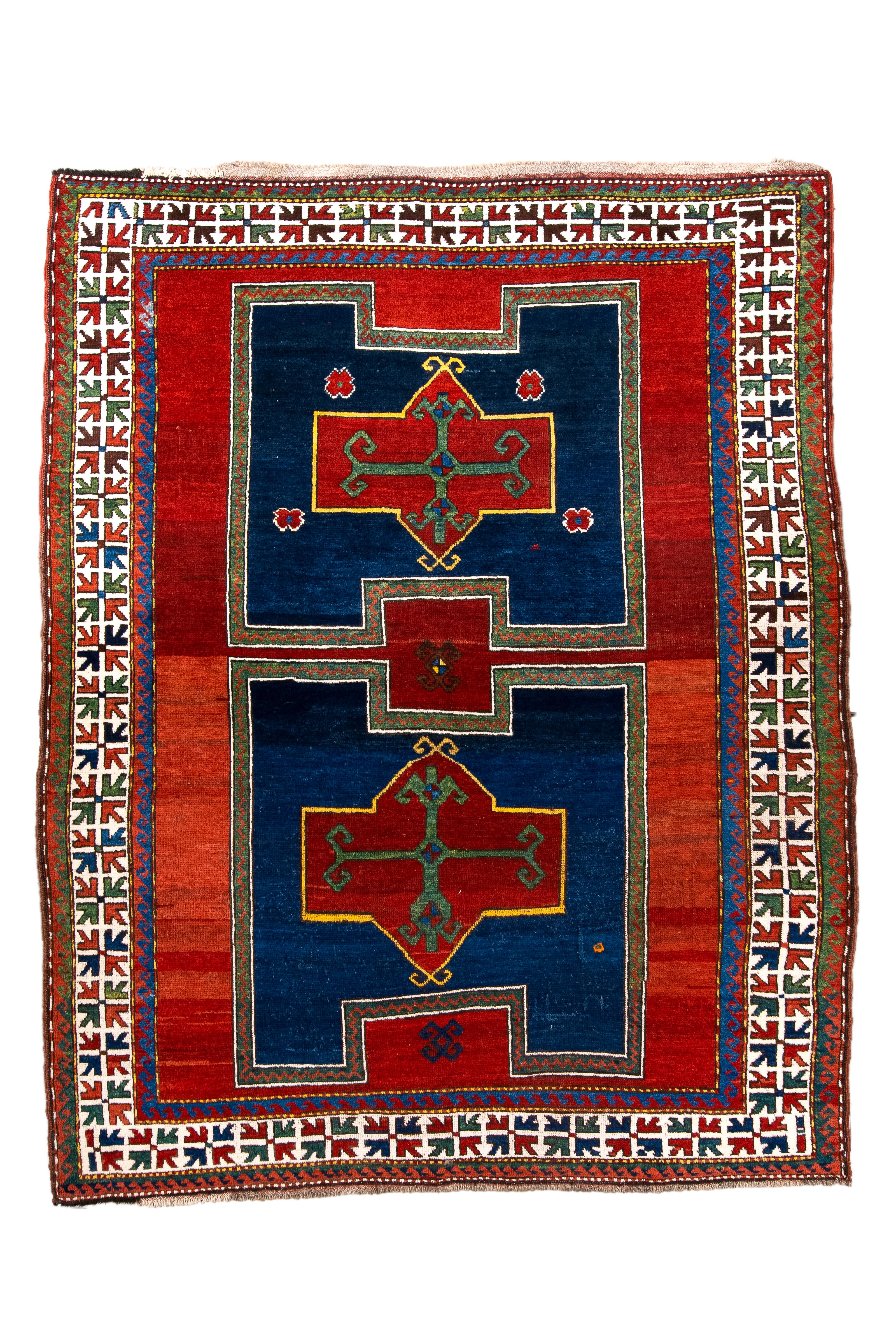 Immerse yourself in the timeless allure of this antique Kazak rug dating back to 1920, showcasing a captivating blueberry and brick-red color scheme. Belonging to the Fachralo substyle of Kazak rugs, known for its intricate designs and sometimes