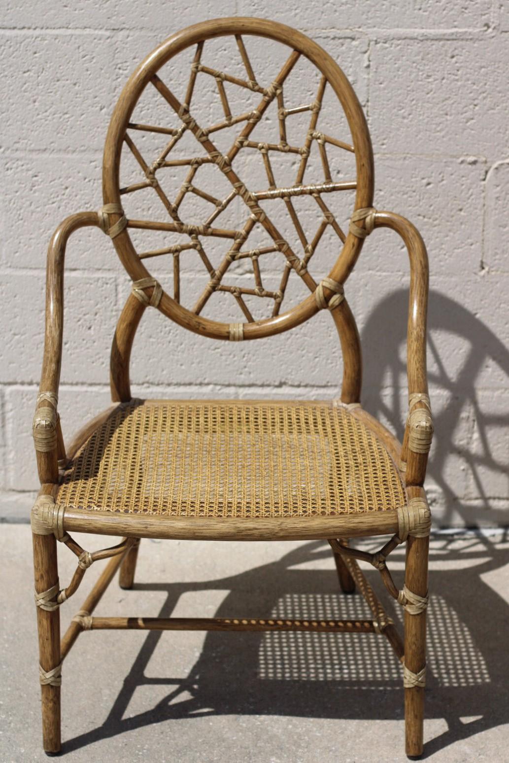 Un ensemble de quatre chaises iconiques en rotin à glace fissurée conçues par l'innovatrice de rupture Elinor McGuire. Le design est célèbre pour son dossier ovale en rotin qui encadre des pièces de rotin plus petites liées par du cuir brut, créant