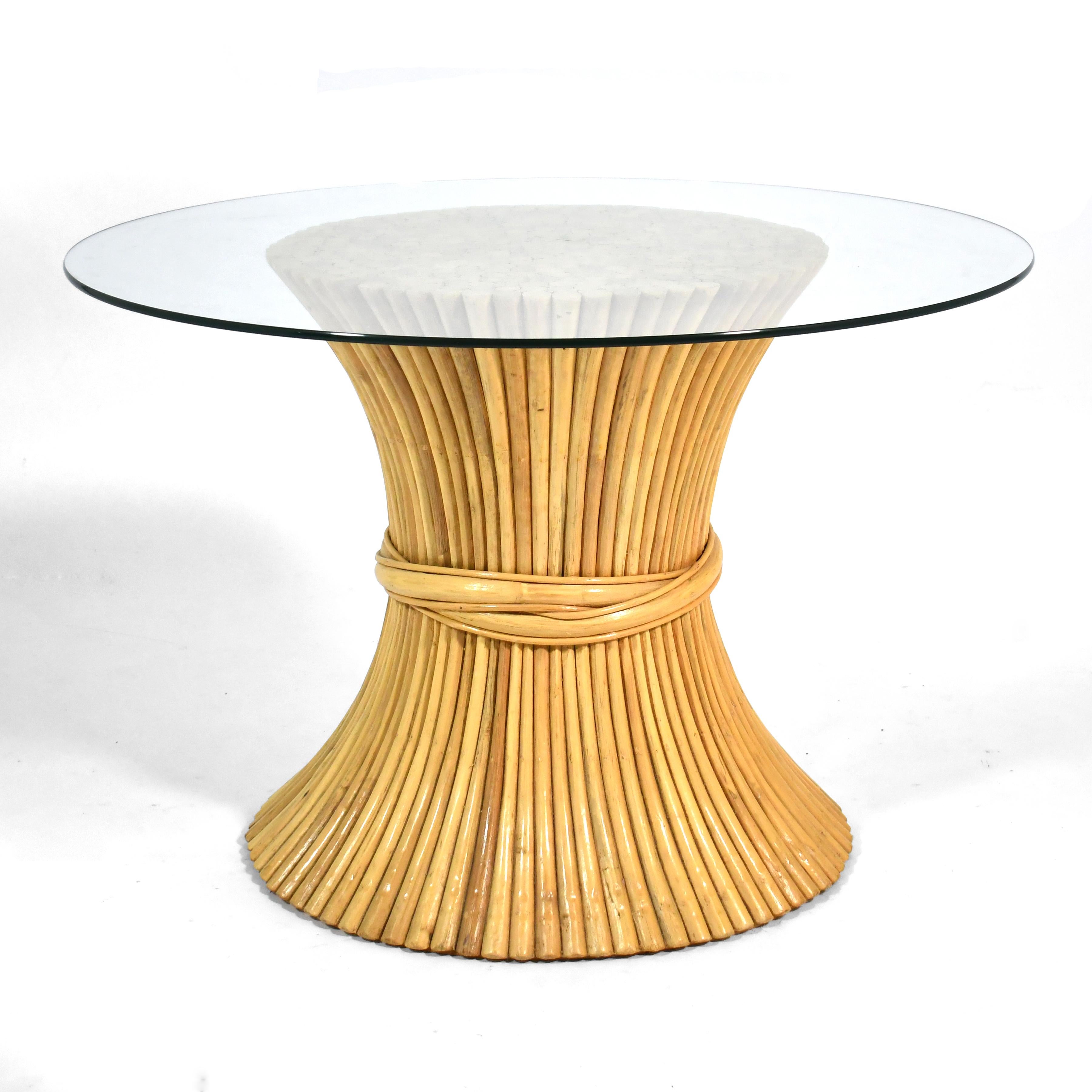 This elegant piece is the perfect center table, and can also serve as a dining table. One of Elinor McGuire's most iconic and enduring designs for McGuire of San Fransisco, the NP-10 dining table has a base of rattan gathered at the waist like a