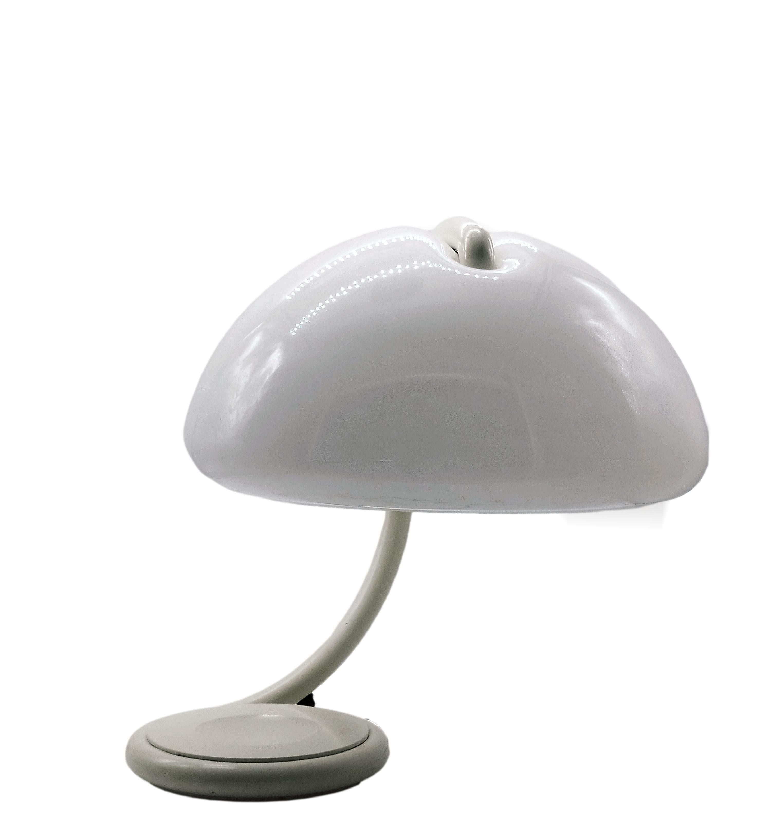 Disegnata nel 1965 da Elio Martinelli, la lampada è realizzata con tecniche di stampaggio del metacrilato innovative per l'epoca in cui è stata progettata e fa rivivere l'atmosfera di quegli anni decisivi per l'affermazione del design italiano nel