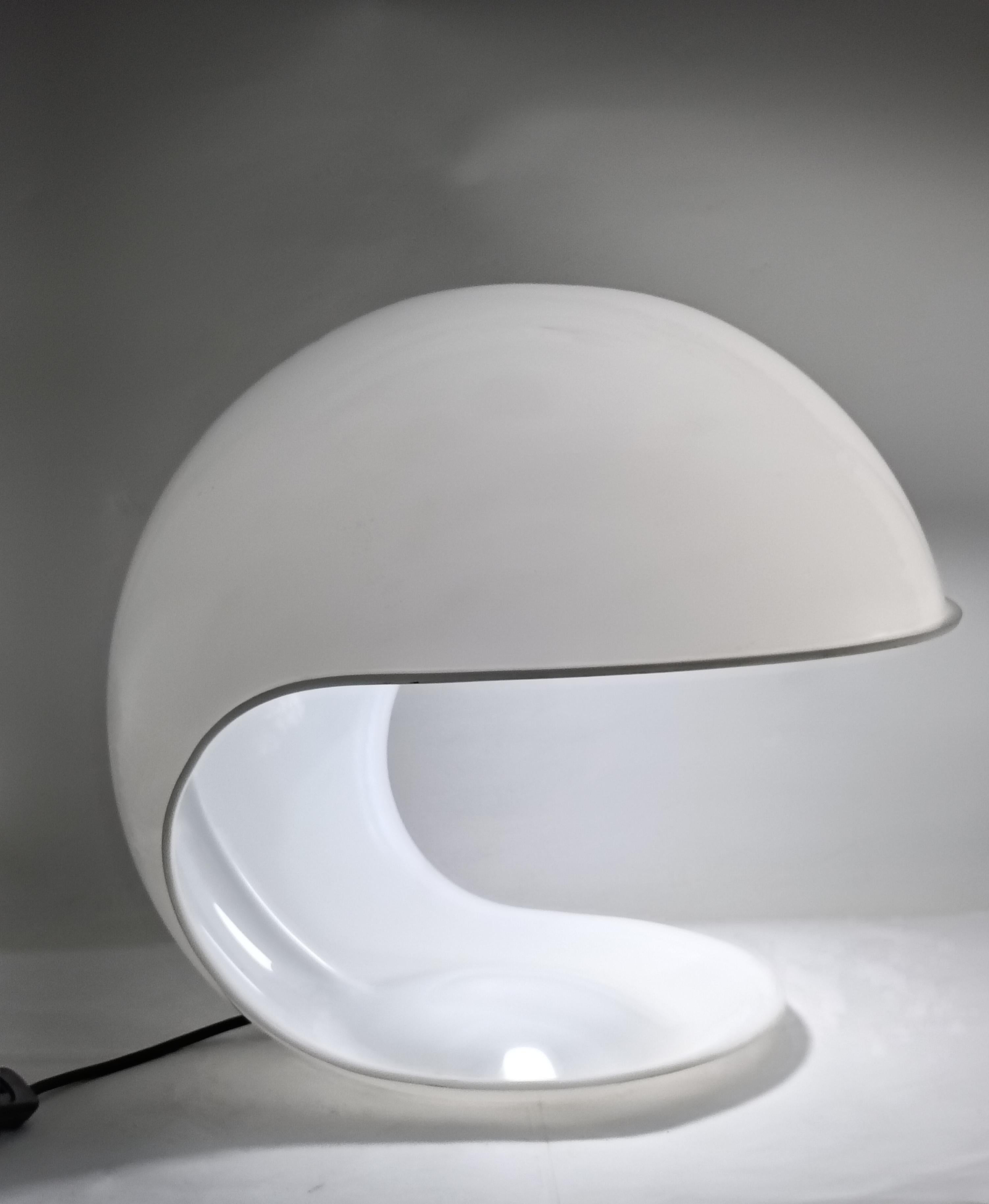 Lámpara de mesa italiana moderna Mod. Foglia, diseñada por Elio Martinelli para la empresa Martinelli Luce en los años setenta.
Lámpara con una sola carcasa de plástico blanco y base redonda de forma irregular. Observe la lesión en la pantalla de la