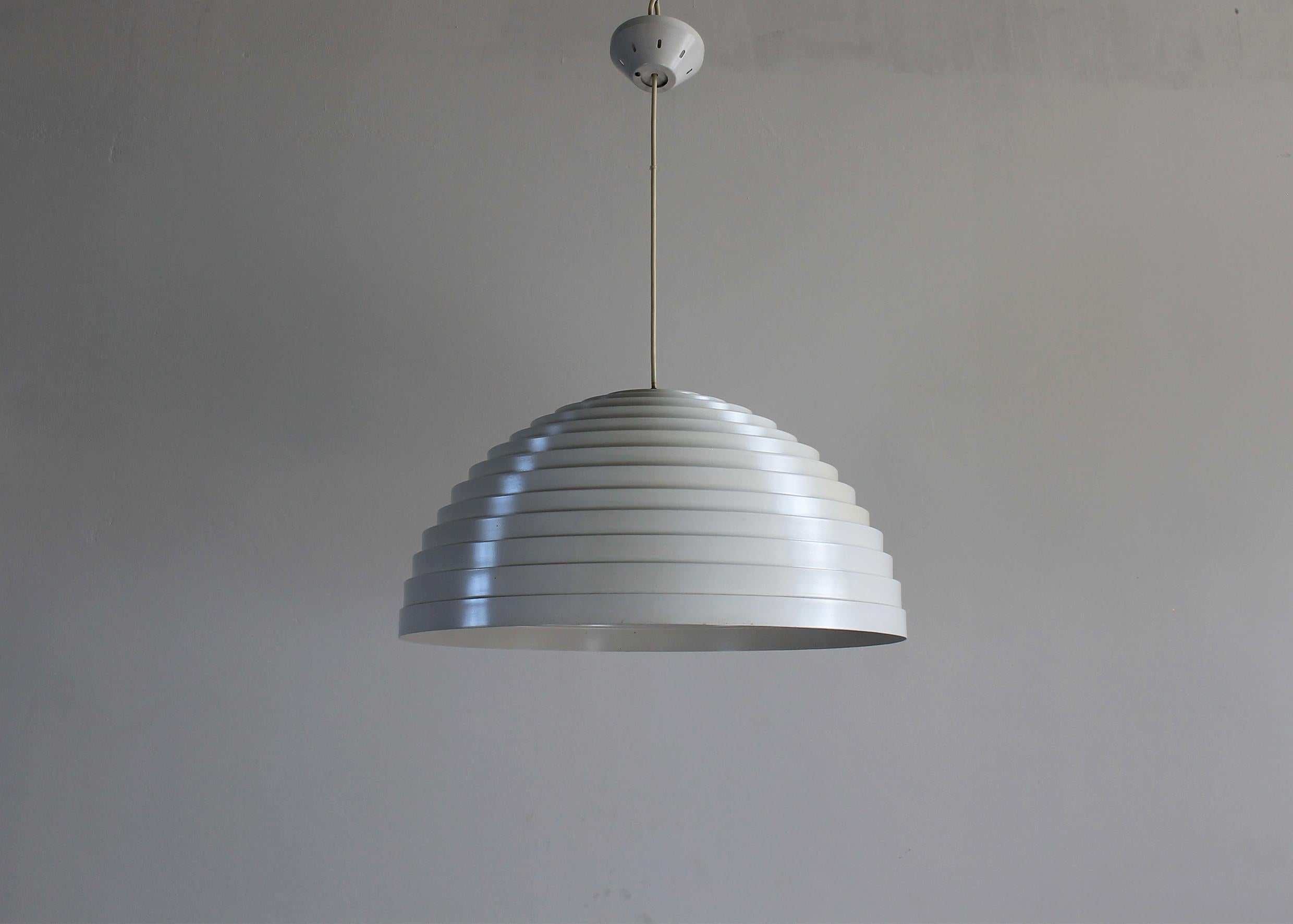 A rare ceiling lamp or chandelier (model Step) with a semisphere lampshade in white lacquered aluminum, it was designed by Elio Martinelli and produced by the Italian company, Martinelli Luce during the 1970s. 

The concentric shapes repeated in a