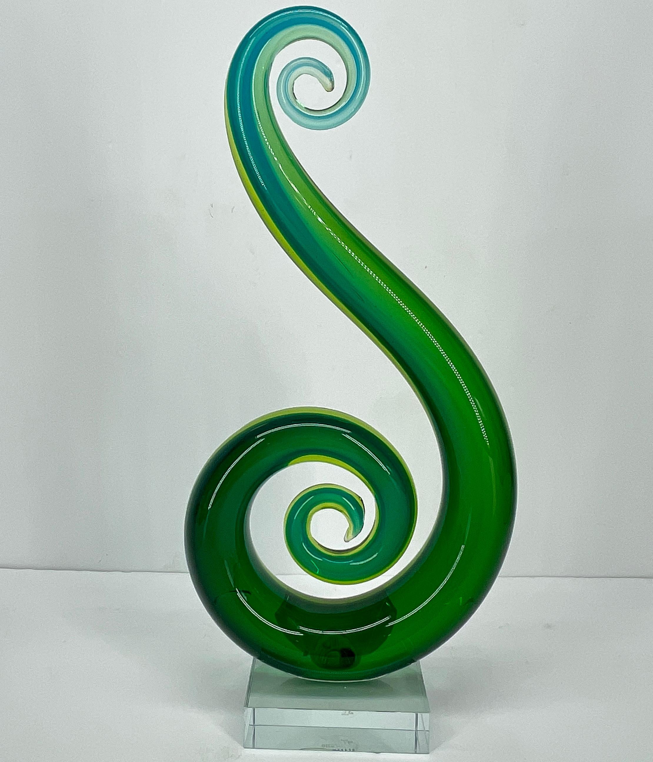 Sculpture en verre de Murano dans le style d'Elios Raffaeli. Cette sculpture sur socle en verre en forme de nautile ou de note de musique allongée est d'une beauté saisissante. La sculpture est de couleur vert émeraude avec un délicat fondu vers le