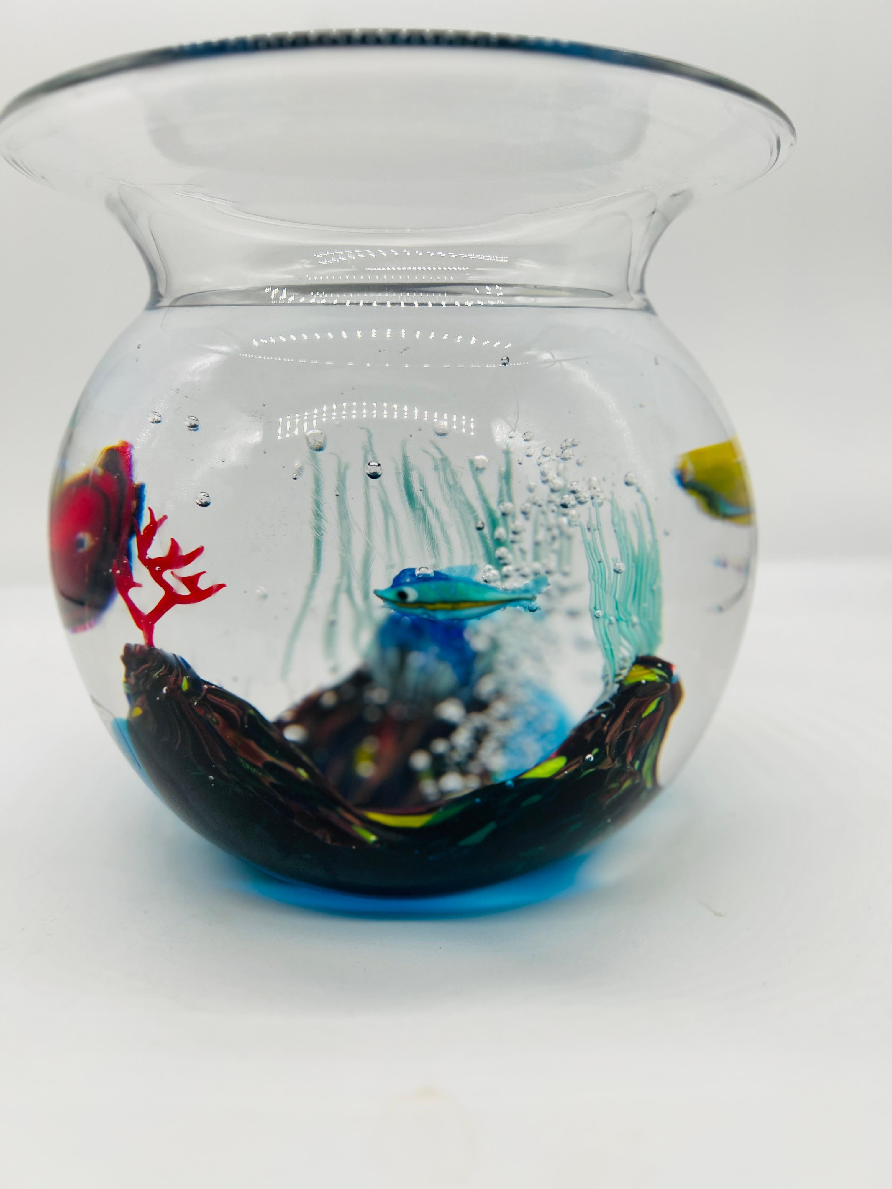 This captivating Murano glass fishbowl sculpture, created by the renowned glass artist Elio Raffaeli for Oggetti, circa 1950, is a stunning example of mid-century Italian glass artistry. The sculpture depicts a vibrant underwater scene, with