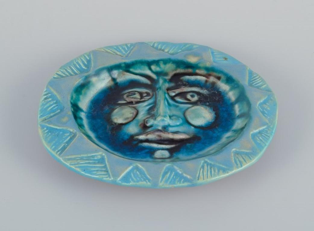 Elio Schiavon (1925-2004), Italien. 
Einzigartige Keramikschale mit blauer Glaseinlage am Boden.
Glasur in Grün- und Türkistönen. Mit dem Motiv eines Gesichts.
Ungefähr in den 1970er Jahren.
Unterschrieben.
Perfekter Zustand mit natürlichem Knistern