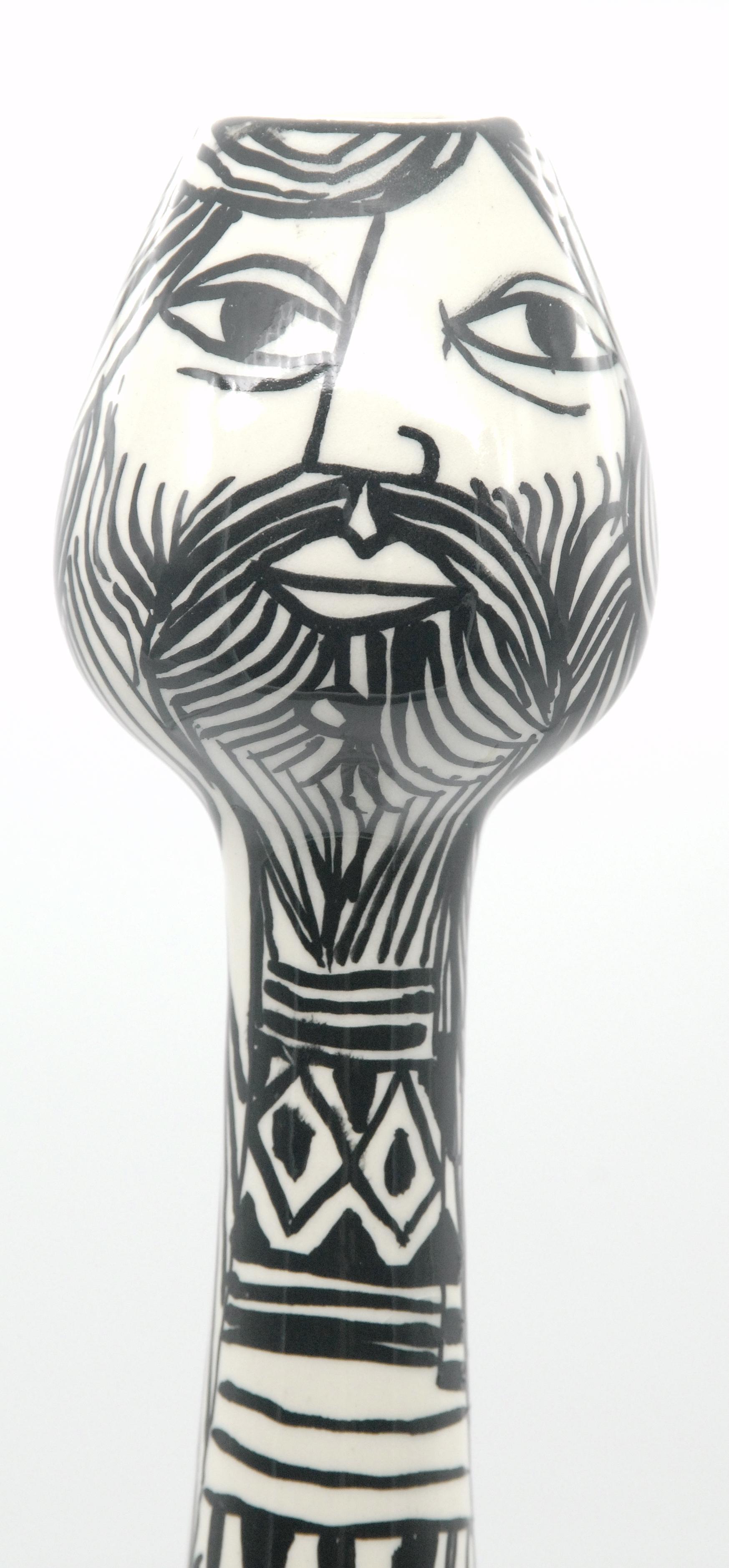A tall black and white cylindrical vase form and painted as a male figure. Fully signed.