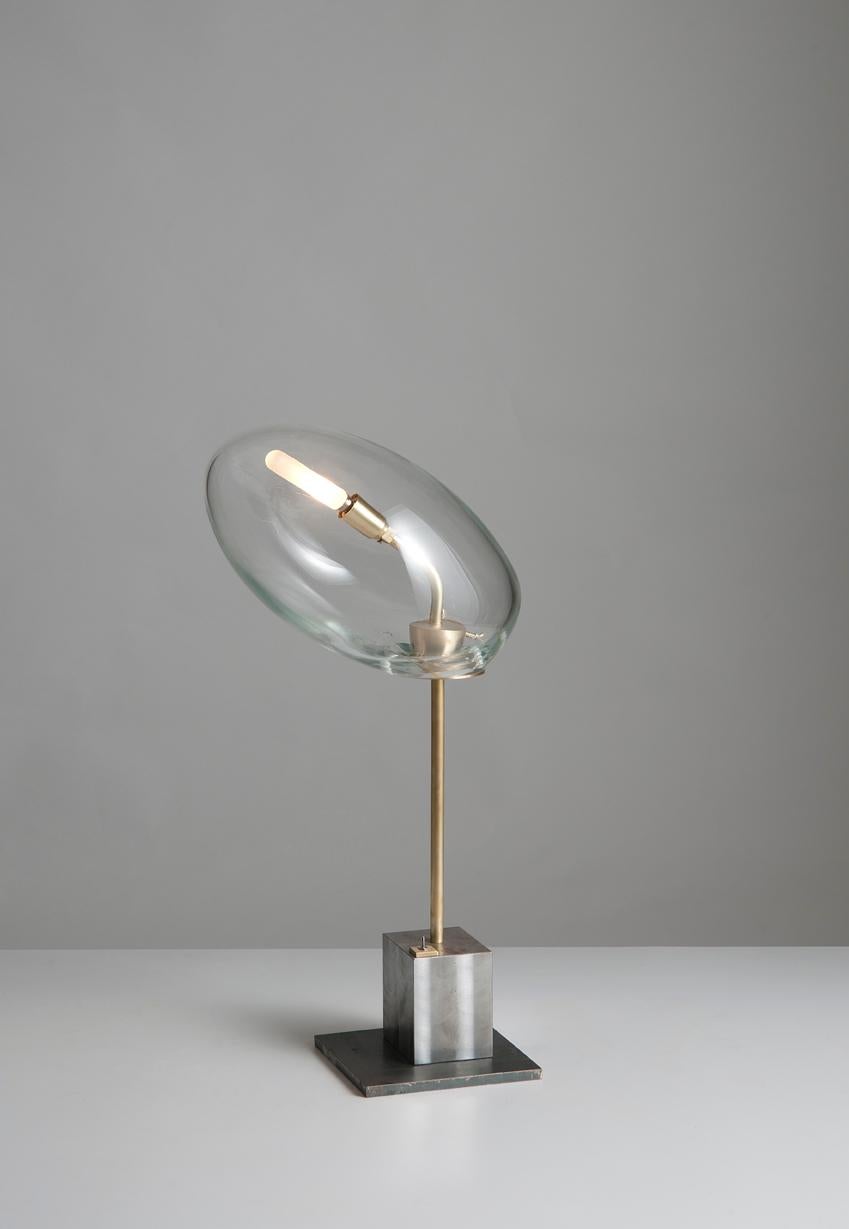 Eliptic liquid lamp by Sema Topaloglu.
Dimensions: 17 x 36.5 x 66.5 cm.
Materials: iron, handblown glass.

Sema Topaloglu is known for her dedication to materials, craftsmanship and a unique aesthetic vision. The tactile and visual relations