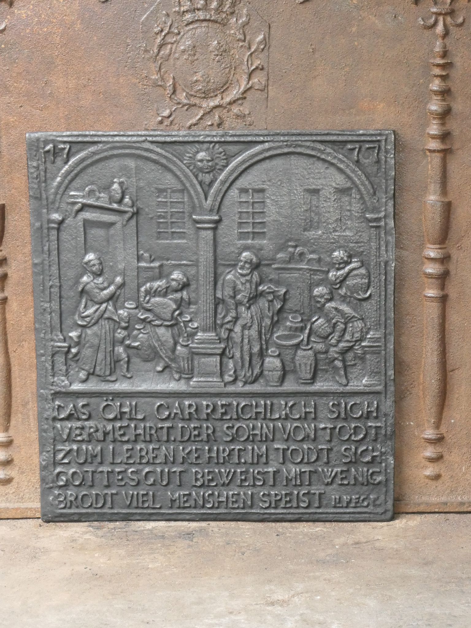 Plaque de cheminée allemande du 20e siècle de style victorien représentant Elisha et l'huile de la veuve. 

La plaque de cheminée est de couleur noir/étain et en bon état sans fissures.