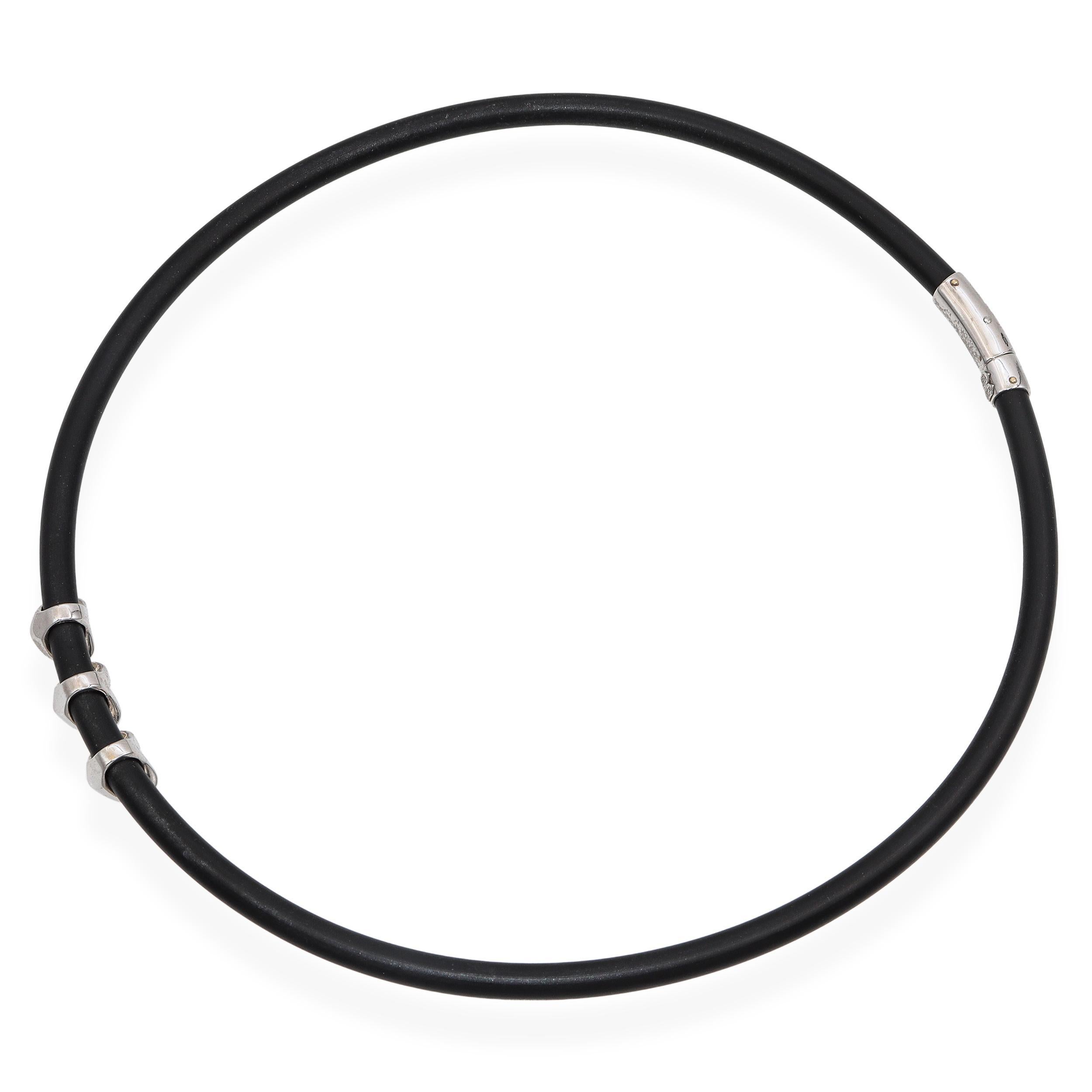 Moderna e chic, questa collana firmata Elite presenta tre scintillanti stazioni a forma di cuore con pavé di diamanti, realizzate in oro bianco 18 carati. Gli eleganti cuori scorrono lungo un elegante cordoncino di gomma nera, offrendo un