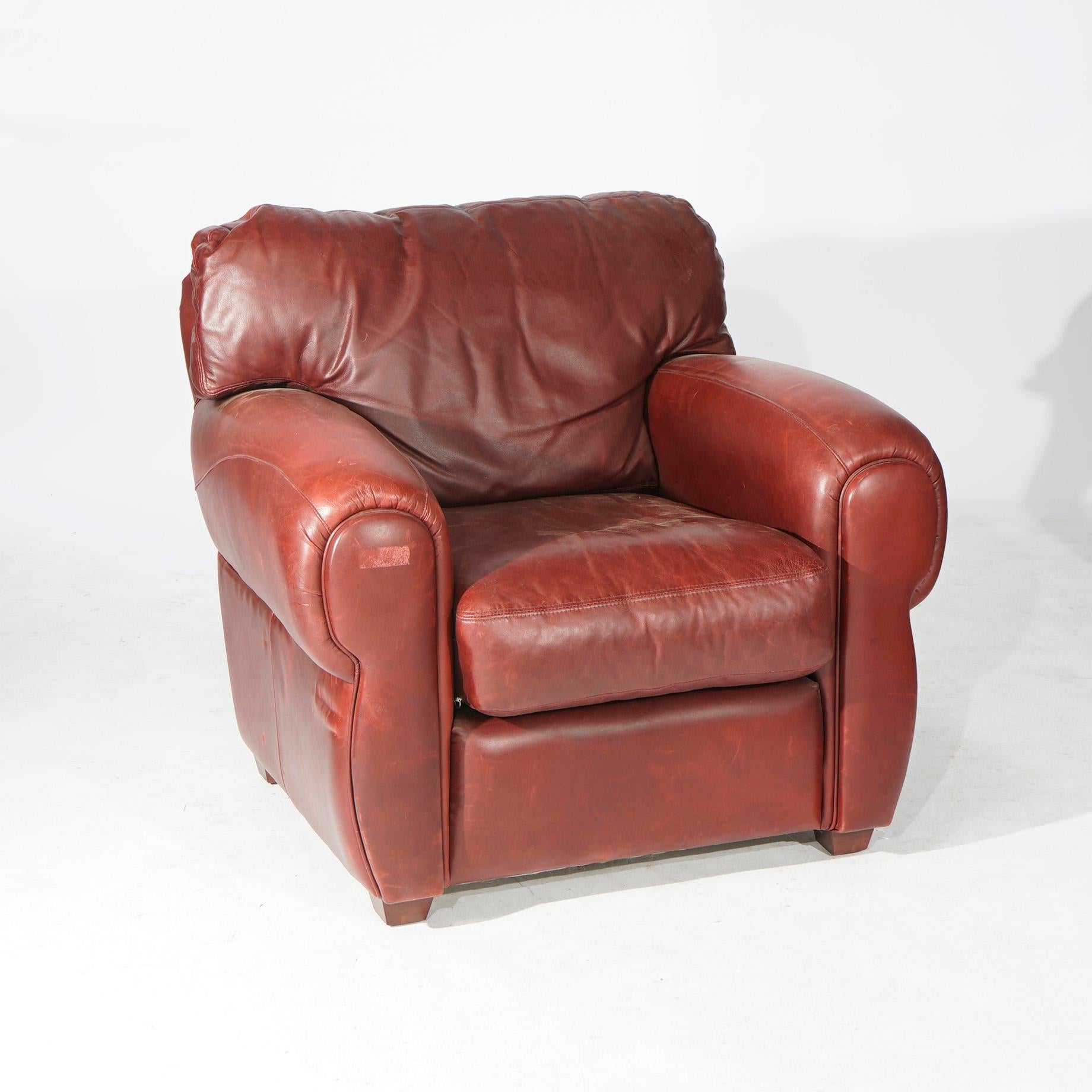 A leather club chair by Elite offers overstuffed form with red/brown (cordovan) leather and has matching ottoman, maker label as photographed, 20th century

Measures- Chair 34'' H x 39.5'' W x 37'' D; Ottoman 16.5'' H x 30'' W x 21.5'' D.
