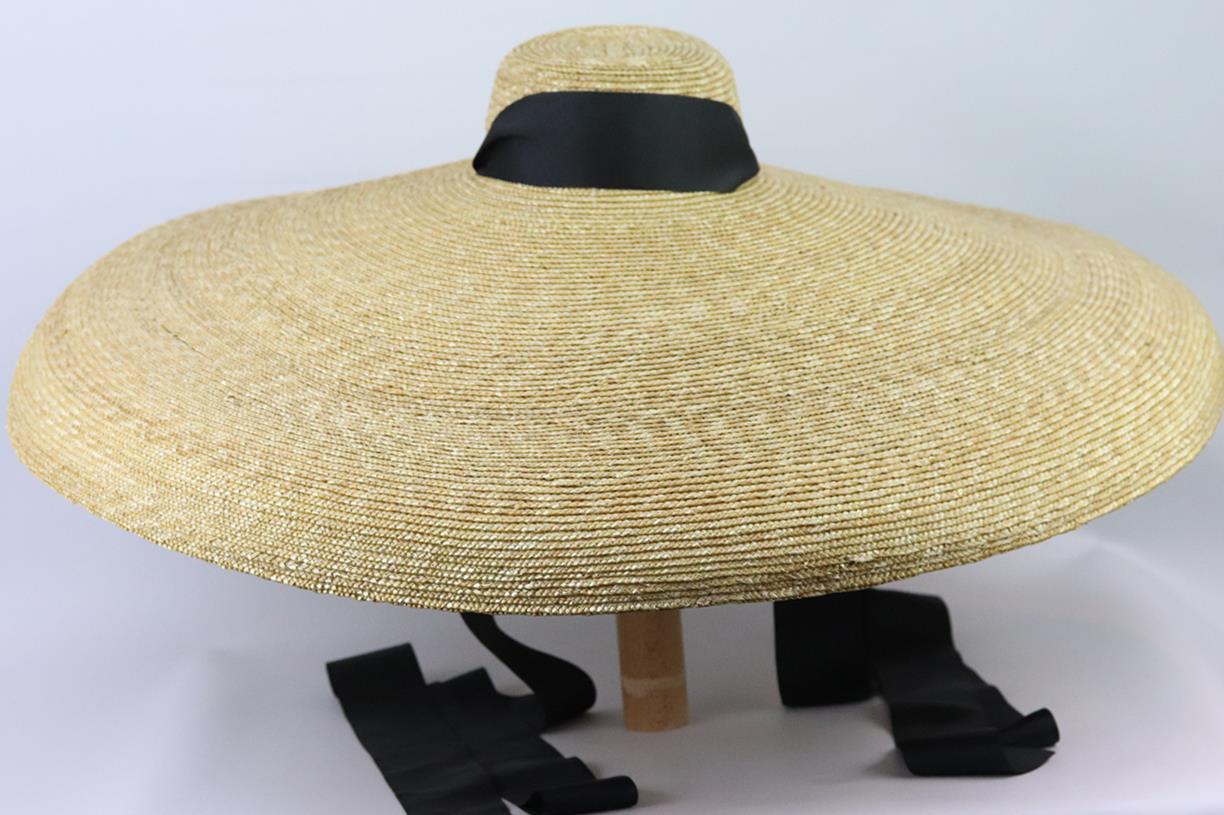 This ‘Pamela’ wide-brim hat by Eliurpi is woven from straw in the label's native Spain, the design is trimmed with a contrasting band that extends into ribbon for you to fasten. Beige straw, black grosgrain. Tie fastening at neck. Does not come with