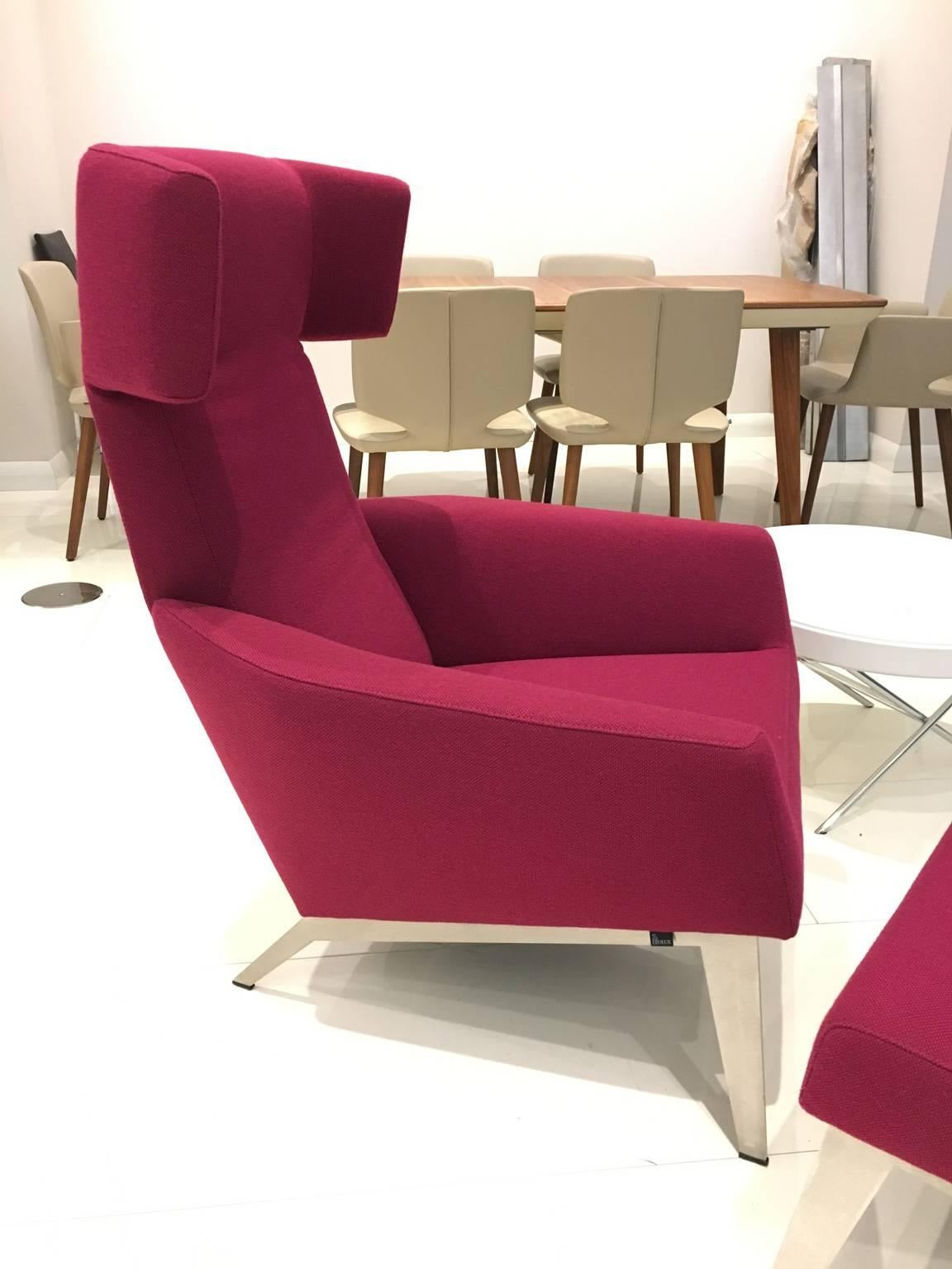 Armchair with recline function and matching ottoman upholstered in magenta fabric. Brushed stainless steel base. 

For almost eight decades, Leolux has been choosing the evolutionary route. Innovation and calm growth, steady but with a clear goal.