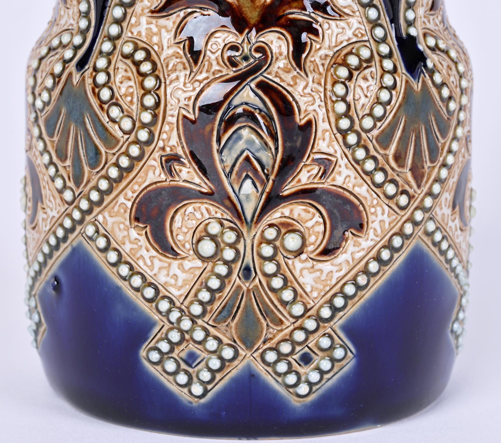 An unusual Doulton Lambeth Aesthetic Movement beaker shaped vase decorated with stylized arabesque and scrolling beaded designs by acclaimed and sought after artist Eliza Simmance and dating from around 1885. The stoneware vase is of cylindrical