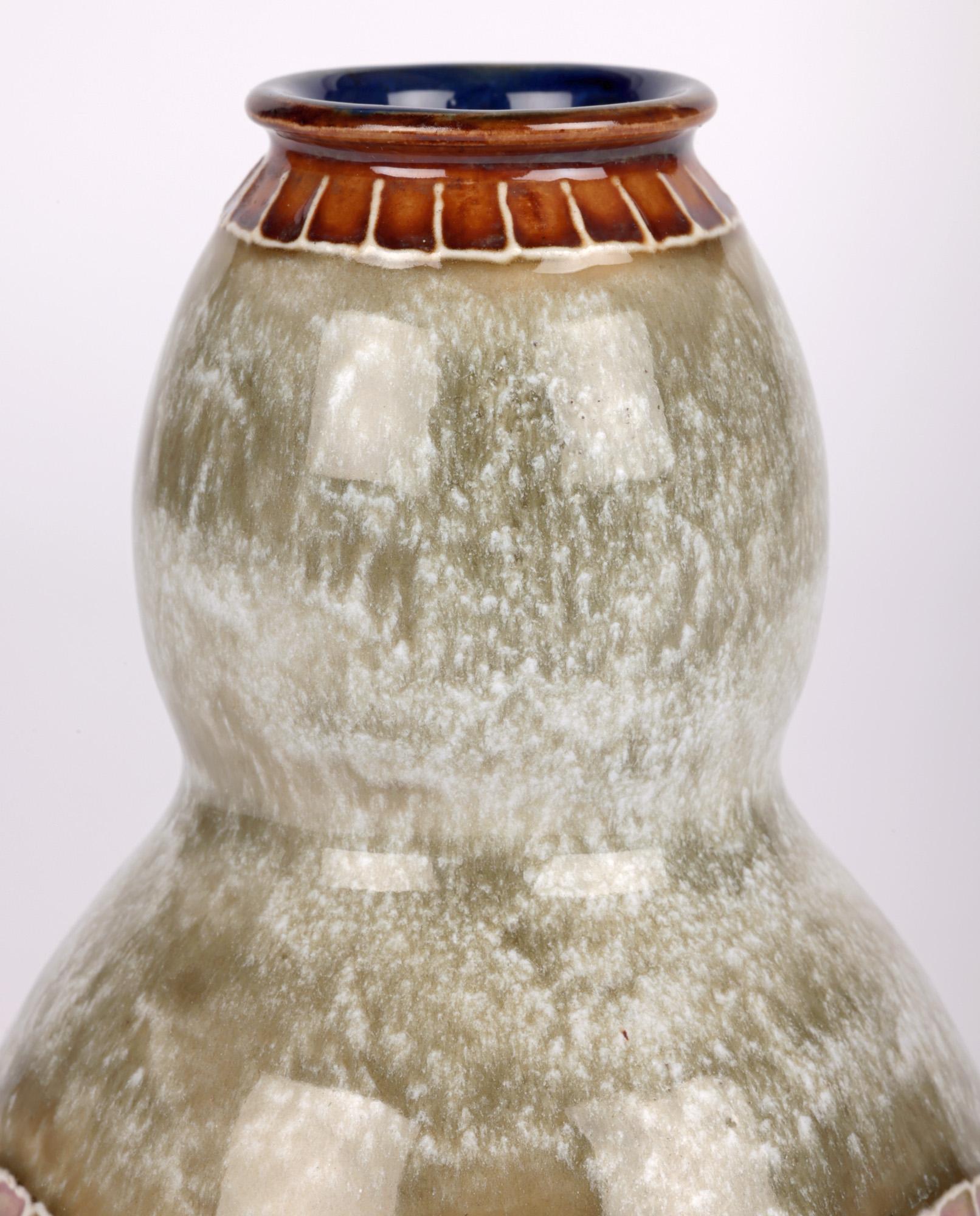 A stunning Doulton Lambeth art nouveau stylized fan shaped floral design vase by renowned artist Eliza Simmance and dated 1905. The stoneware vase is of double gourd shape standing on a flat unglazed narrow round foot with recessed base. The lower