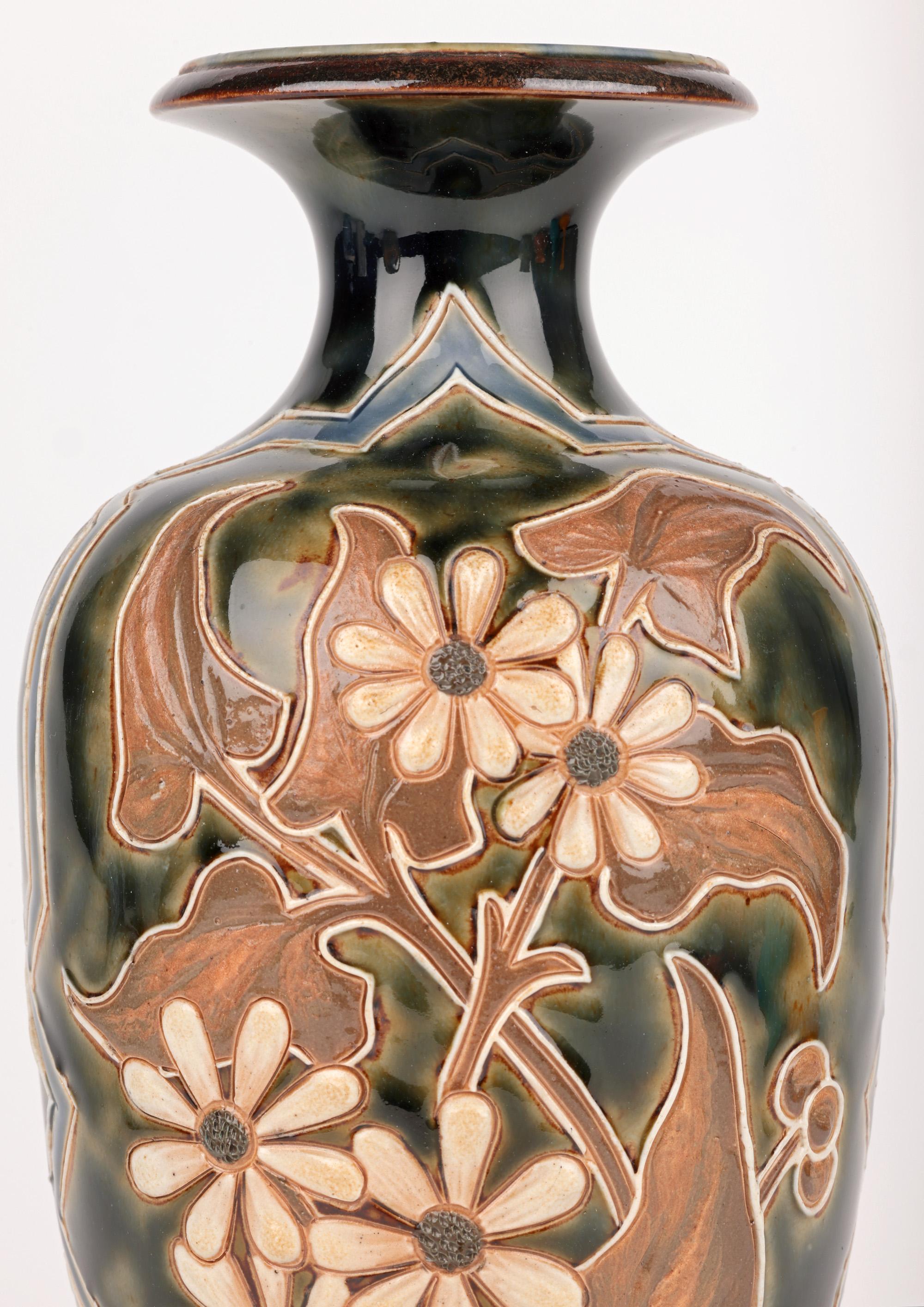 Un élégant vase Doulton Lambeth Aesthetic Movement en poterie d'art, décoré de tiges fleuries par l'artiste acclamée et recherchée Eliza Simmance et daté de 1884. Le vase en grès est de forme bulbeuse, reposant sur un large pied rond, avec une base