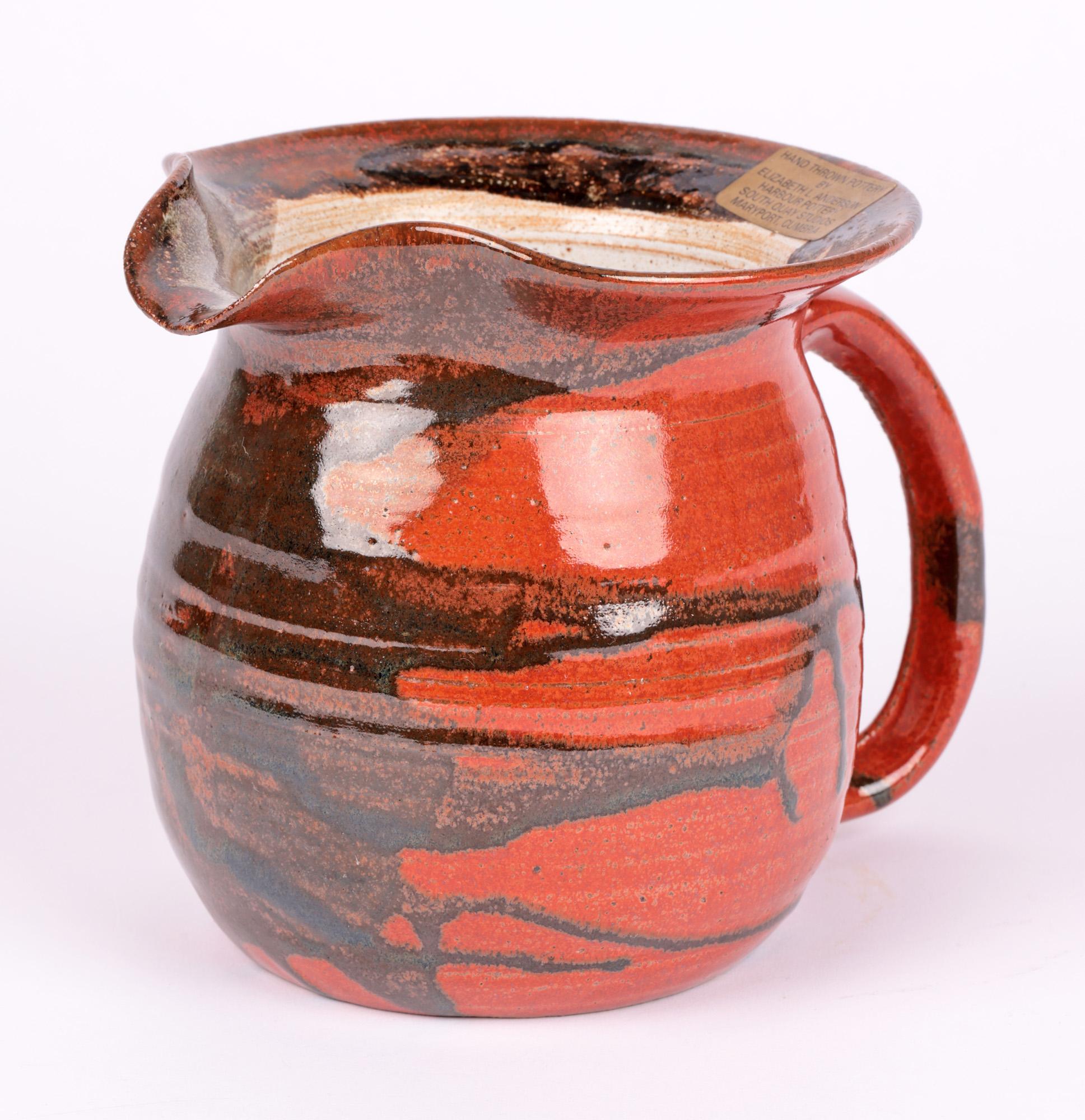 A stylish and finely made studio pottery jug and vase decorated in trailed glazes by Elizabeth L Anderson and made at the Harbour Pottery at South Quay Studios in Maryport, Cumbria and dating from the 20th Century. Both are of round bulbous shape