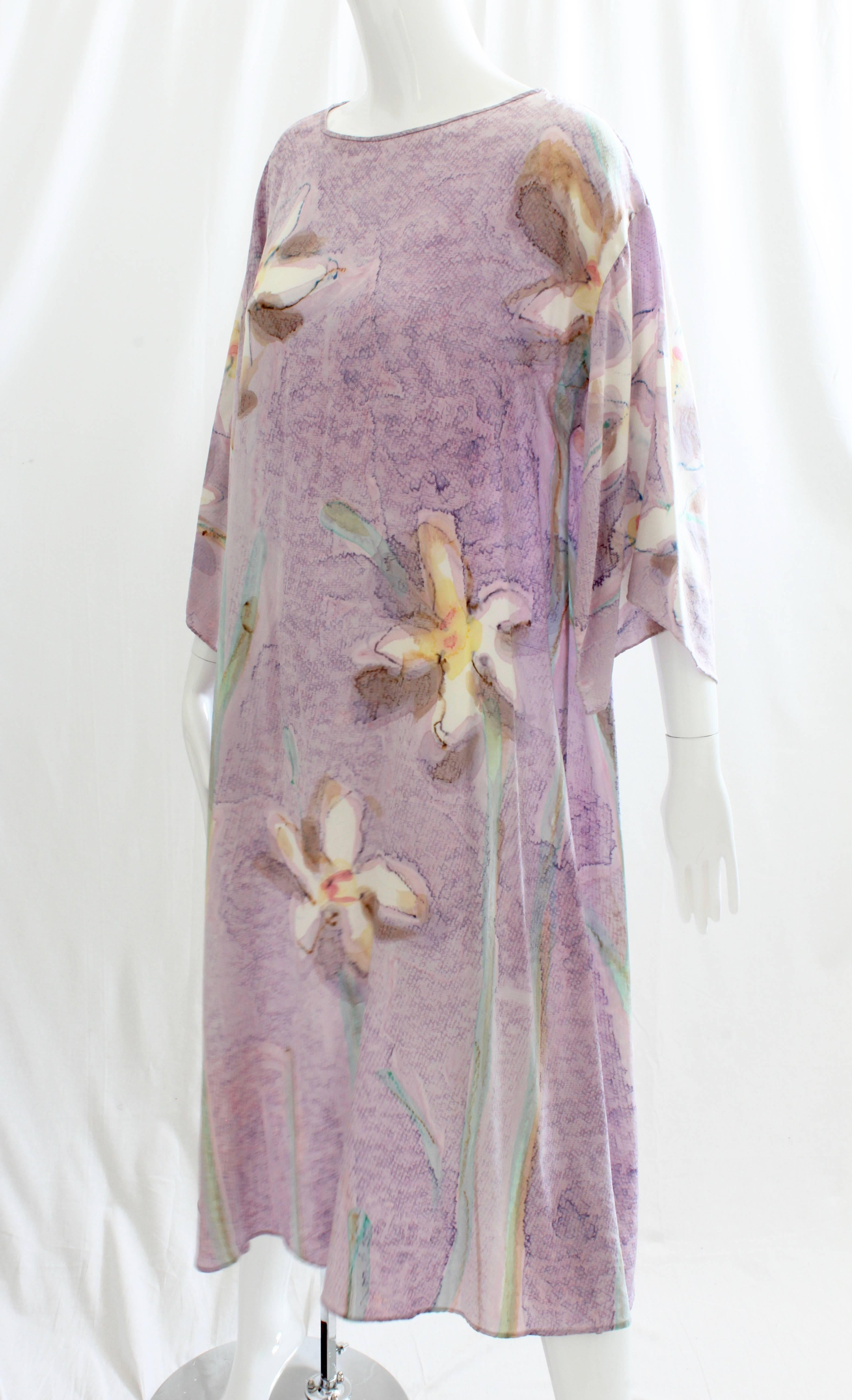 This pretty kaftan or caftan dress was made by David Stiffly for Elizabeth Arden The Salon, likely in the early 1980s. Made from what we believe is silk (no content tag), it features gorgeous watercolor florals against a pale lilac background.