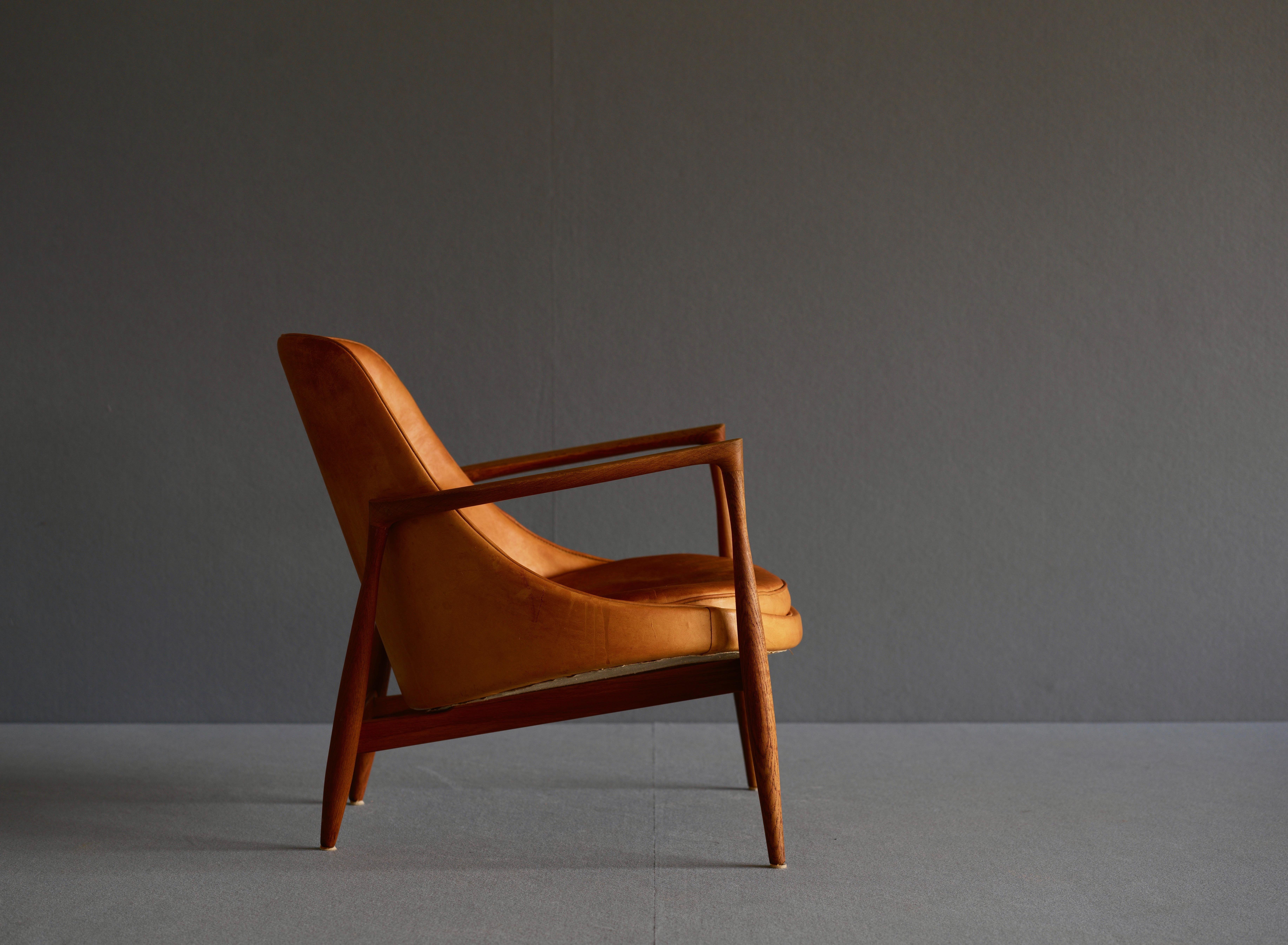 “Elizabeth” chair by Ib Kofod-Larsen by Christensen & Larsen Cabinetmakers. It is in oak with the seat and back upholstered in patinated natural leather. It is circa 1960. The original stamping remains.

These chairs were initially known as the