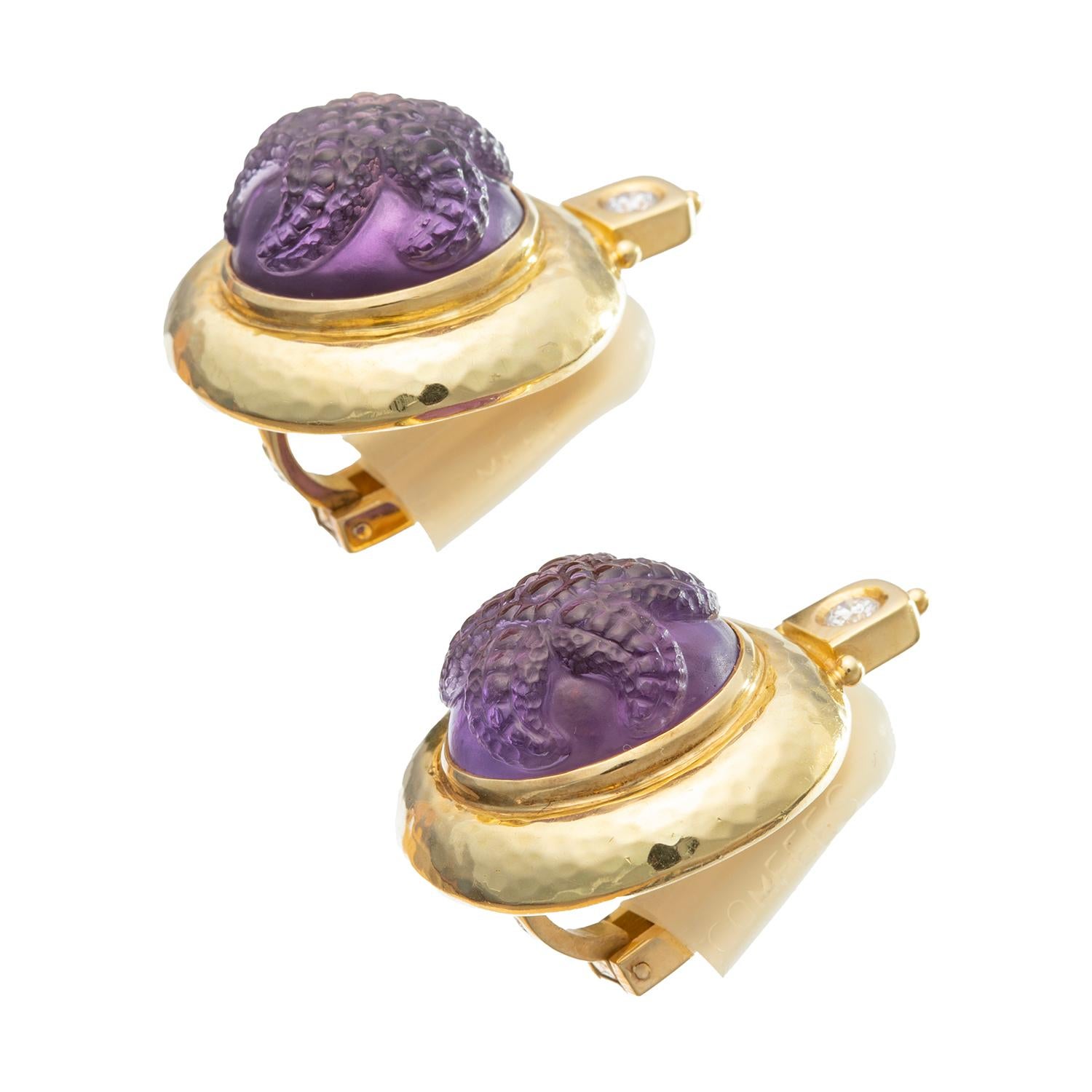 Elizabeth Gage clip earrings in hammered 18k yellow gold each centering a bezel-set cabochon-cut amethyst with a carved starfish, as well as round brilliant-cut diamond surmount.  Amethysts measuring approximately 16mm in diameter.  Two diamonds
