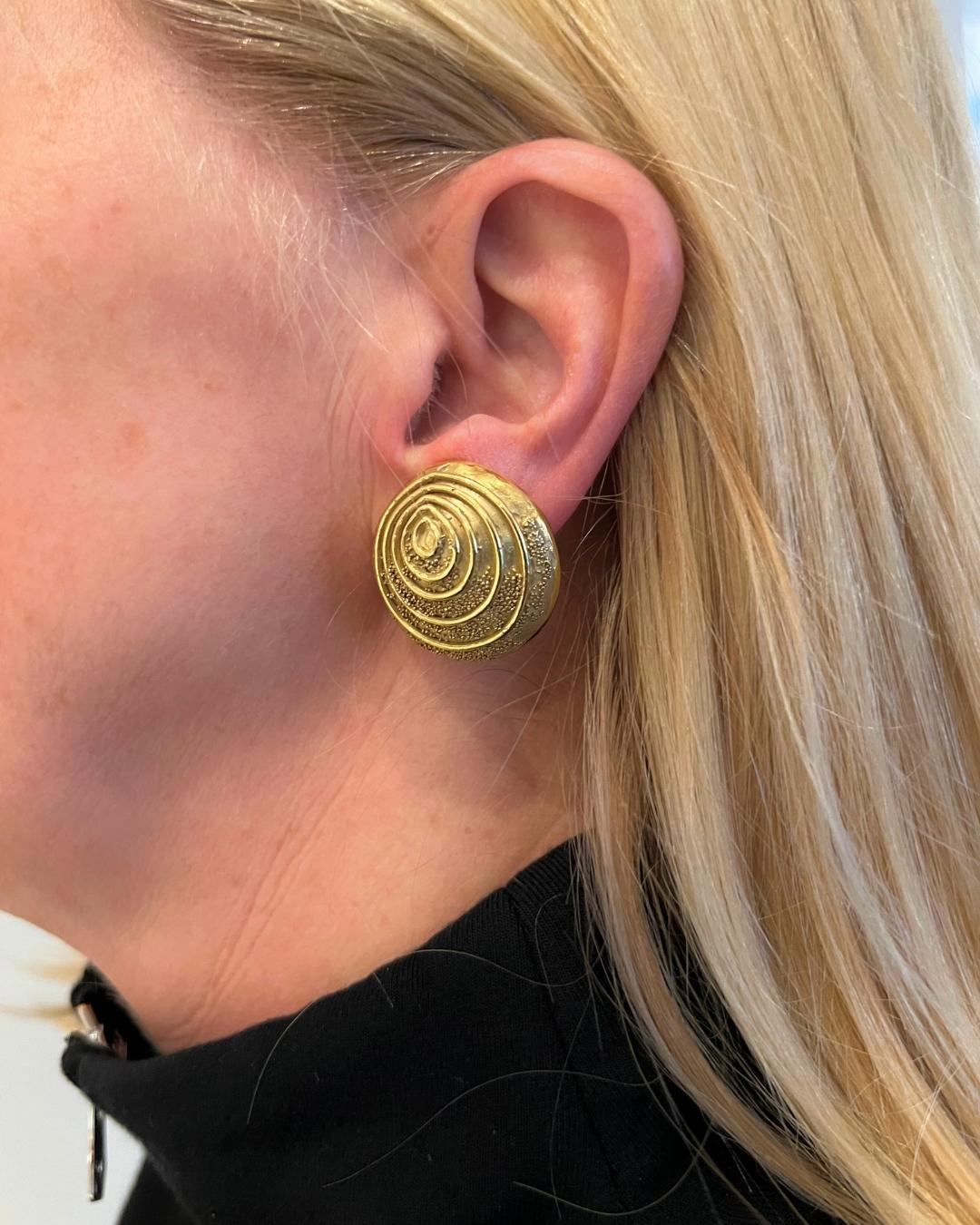 These handmade 18-karat yellow gold ear clips, designed by famed designer Elizabeth Gage in the United Kingdom, showcase her signature craftsmanship in gold and attention to detail. Designed as 1-inch circular earrings, they feature graduated circle