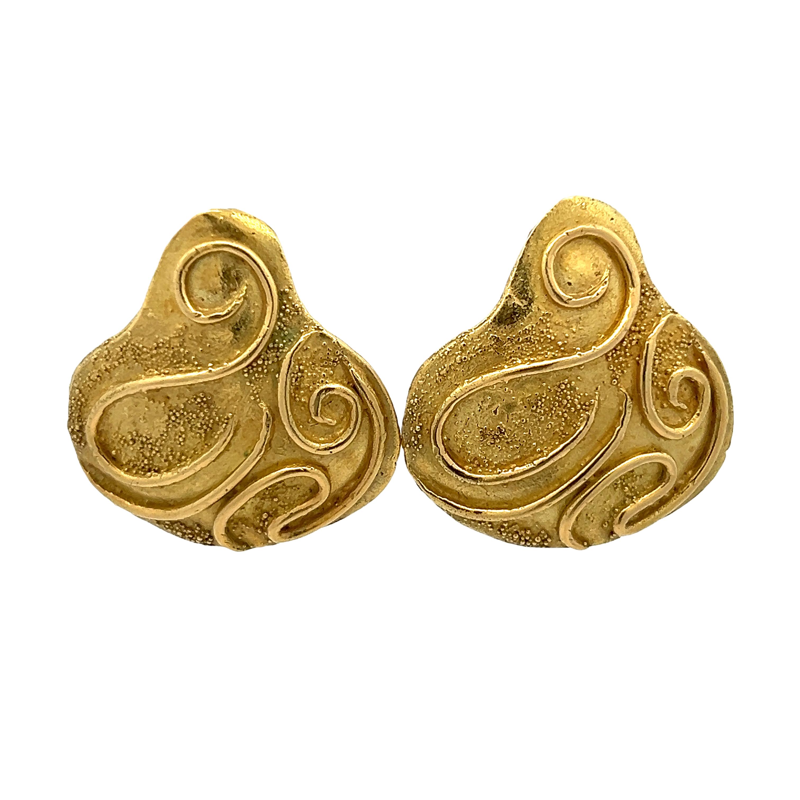 Elegant and richly textured, these 18K yellow gold earrings by renowned British designer Elizabeth Gage showcase her signature artistry and craftsmanship. The organic, shield-like forms are adorned with raised swirl motifs and delicate granulation,