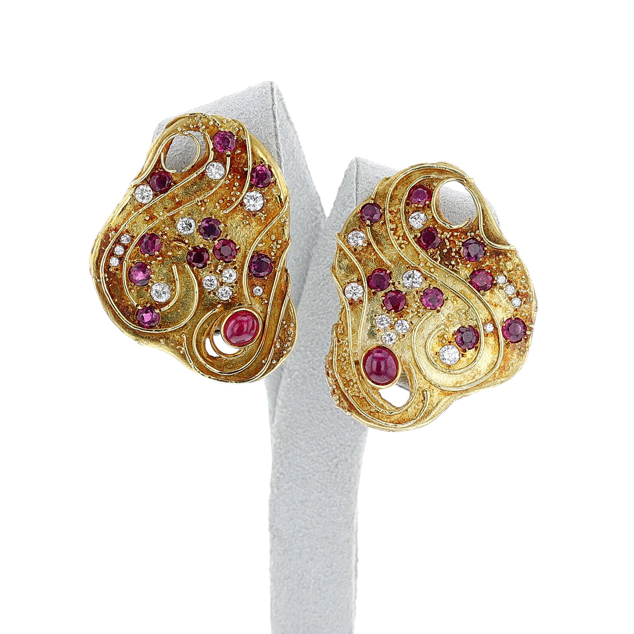 Paire de boucles d'oreilles Elizabeth Gage en or jaune 18 carats avec rubis et diamants. Le motif est composé de rubis ronds et cabochons et de diamants. Les dimensions sont de 40 x 35 mm. Signé Gage, et marques françaises pour l'or 18k. Le poids