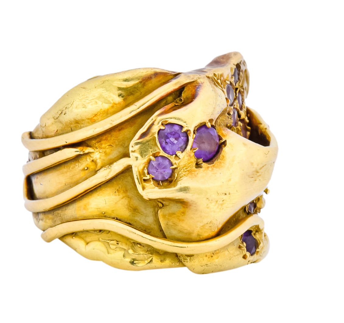 Wide band style ring with organic motif and textured finish

Accented by single cut amethysts, medium-light lilac in color

Signed Gage with maker's mark for Elizabeth Gage

With British Hallmarks for 18 karat gold, London, dated 1986

Ring Size: 6