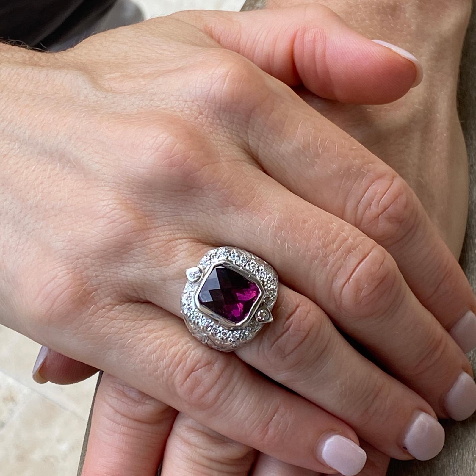 Beautiful rubelite and diamond ring by designer Elizabeth Gage fashioned in 18 karat white gold. The approximately 5.50 carat cushion shape diagonal checkerboard faceted rubelite gemstone is bezel set and surrounded by 34 round brilliant cut