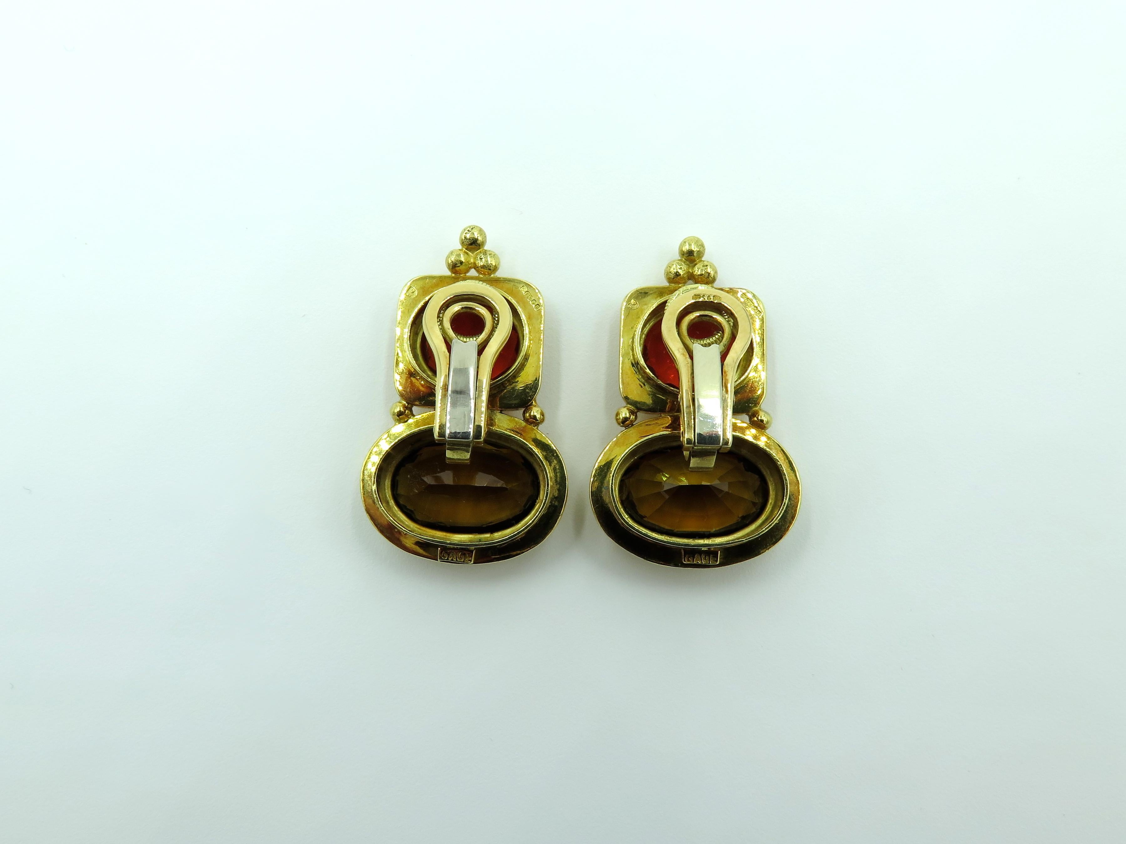 A pair of 18 karat yellow gold, andalusite and fire opal earrings. Elizabeth Gage. Designed as polished gold plaques, set with a horizontally set oval cut andalusite, measuring approximately 15.50 x 10.00 x 7.60mm, and weighing approximately 7.00