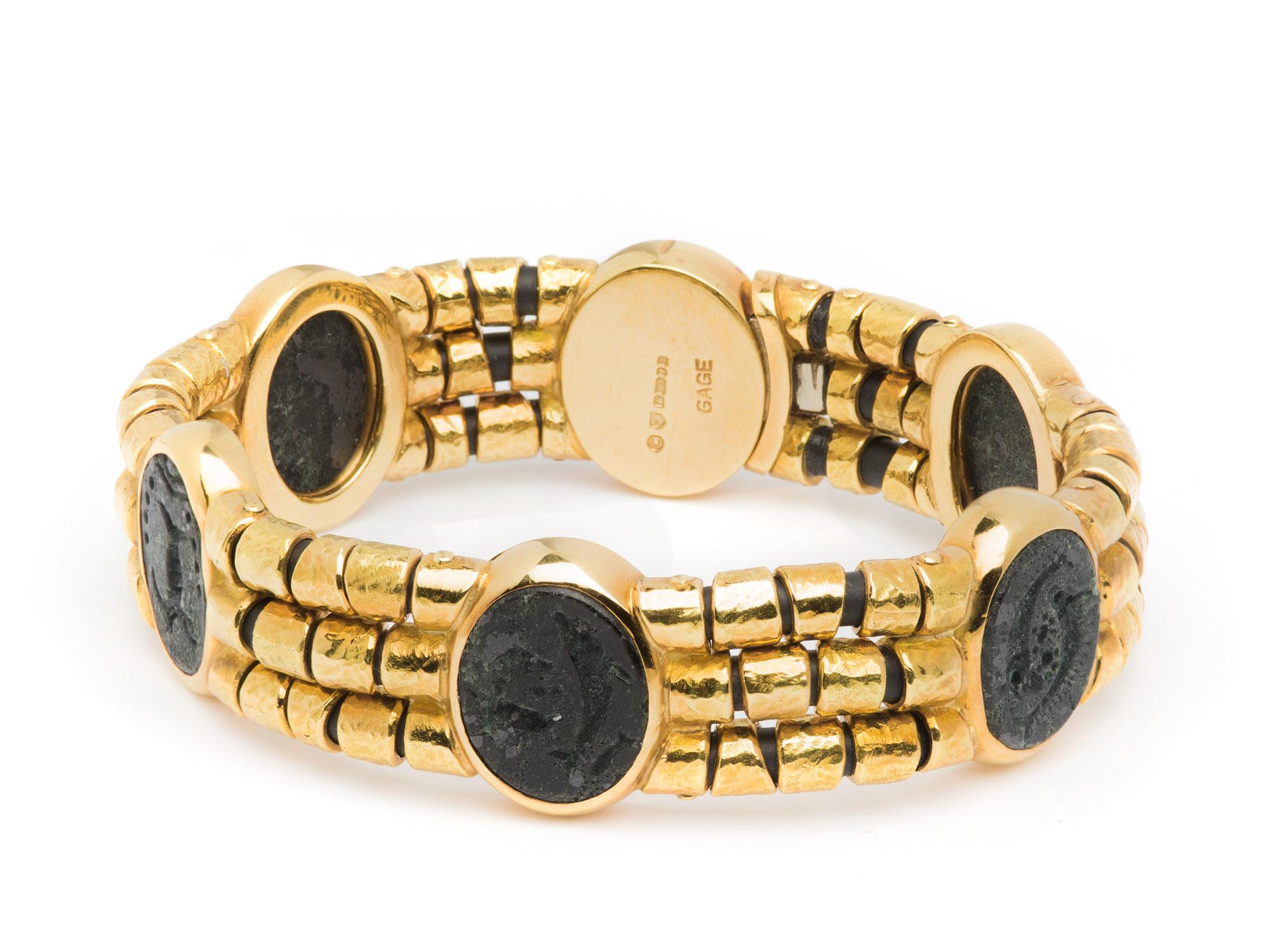 Elizabeth Gage Bracelet with (6) Oval Marine Motifs made out of porous hardstone set with (3) rows of hammered gold barrels on flexible cord.  Signed Gage, British Hallmarks, 18k, Circa 2000.