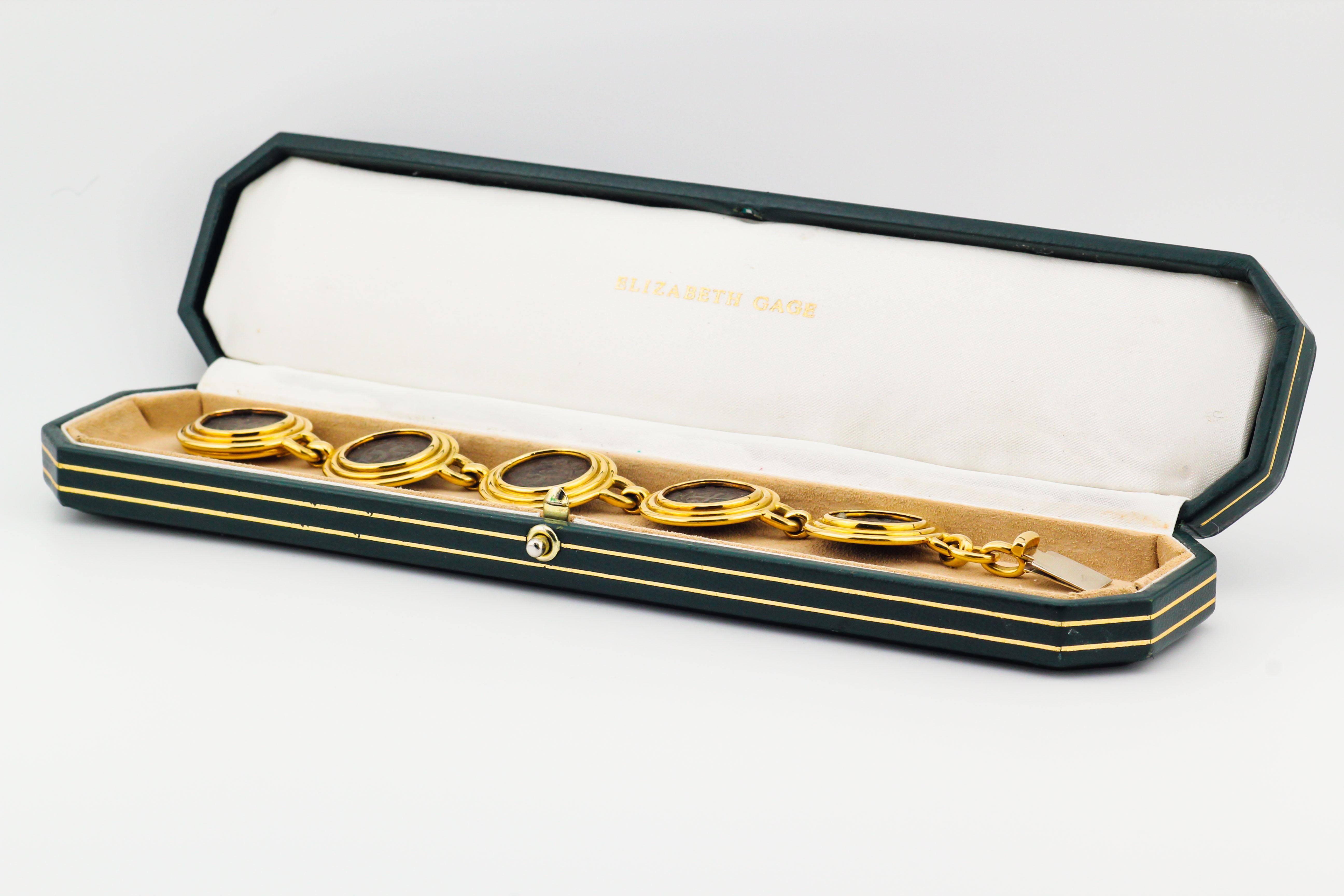 Pour votre considération, le bracelet en or jaune 18k avec pièce médiévale suivant est un bijou unique et luxueux conçu par la célèbre créatrice de bijoux Elizabeth Gage. Il présente une combinaison d'éléments historiques et d'artisanat exquis.

Le