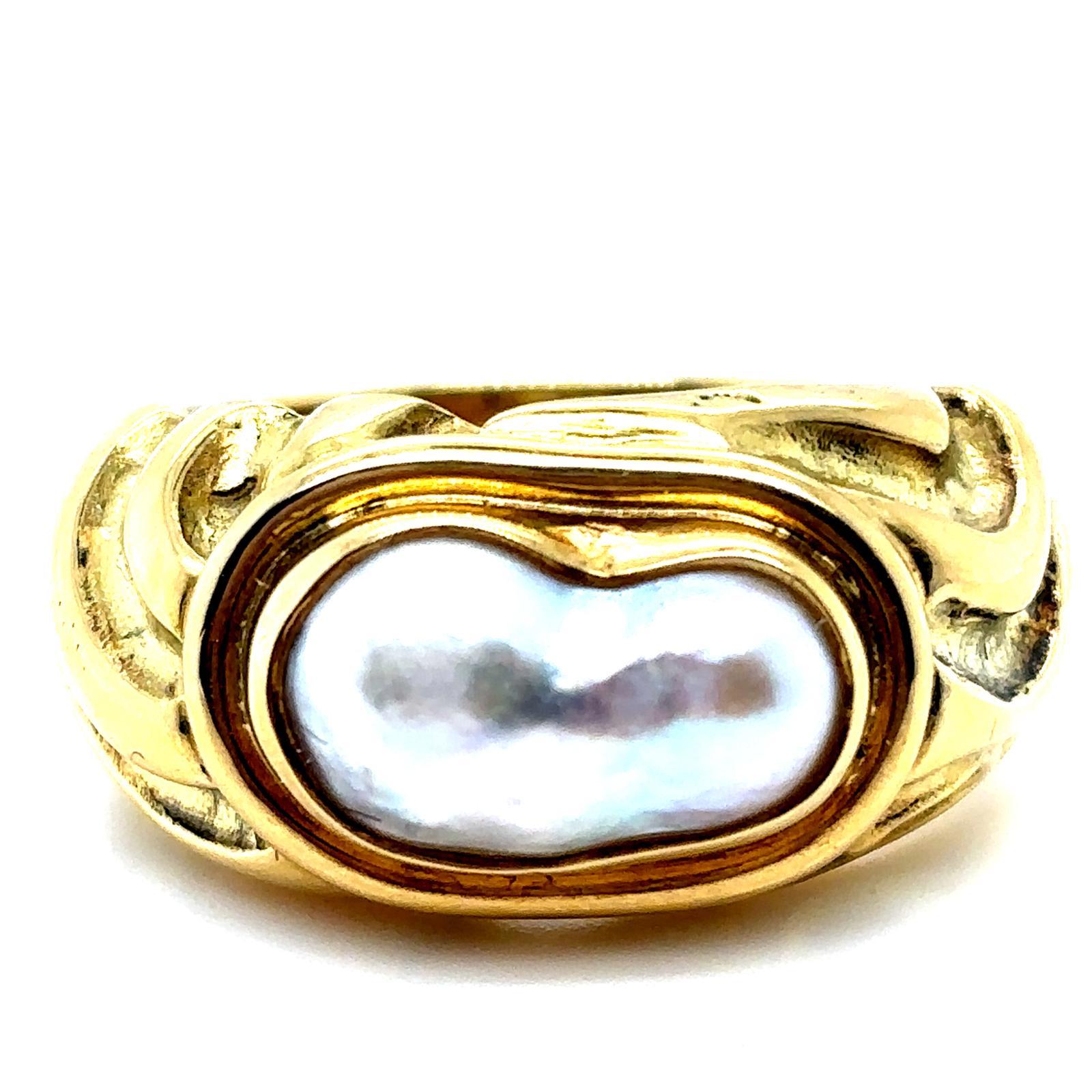 A retro Elizabeth Gage pearl molton gold ring, circa 1990

Designed as a bold heavy 18 karat yellow gold ring of curved organic form - crafted to depict gold in its molton liquid state deeply etched throughout with scrolled detail.
Set to its centre