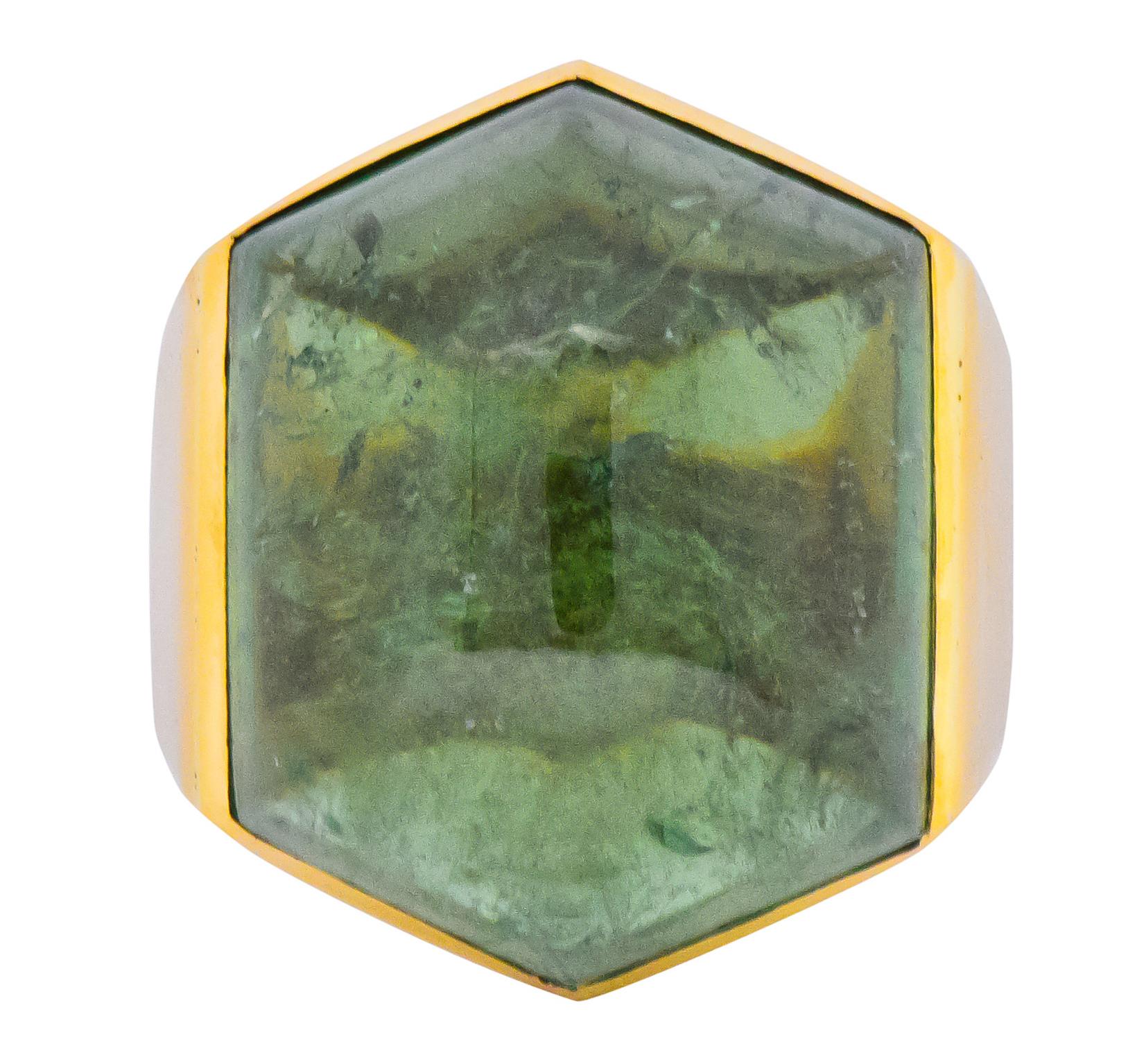 Centering a hexagonal cabochon tourmaline measuring approximately 1 1/4 x 1 1/8 inch, transparent medium-light forest green color

Bezel set into high polished 18 karat gold mount and shank

Stamped 750 for 18 karat gold with British hallmarks and