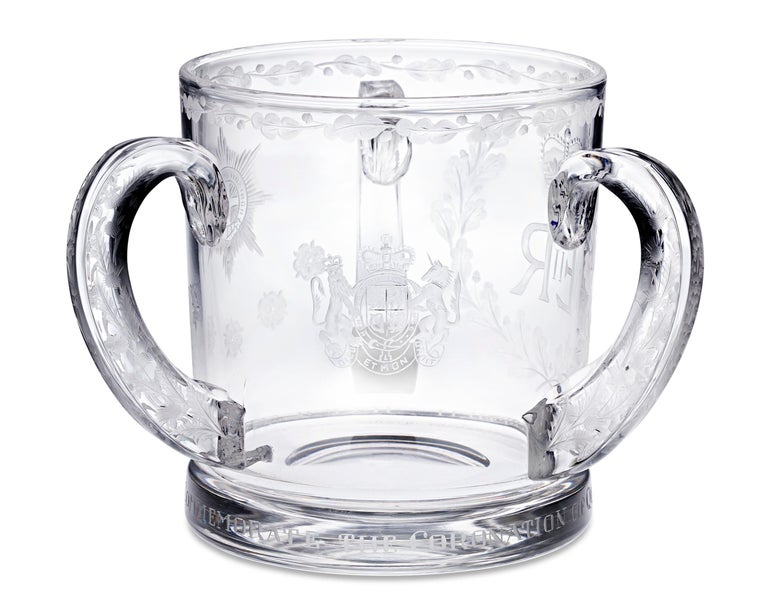 Created to commemorate the coronation of Queen Elizabeth II, this engraved glass tyg is a beautiful celebration of this historic event. Held at Westminster Abbey, it was the first official celebration of its kind to ever be televised — approximately