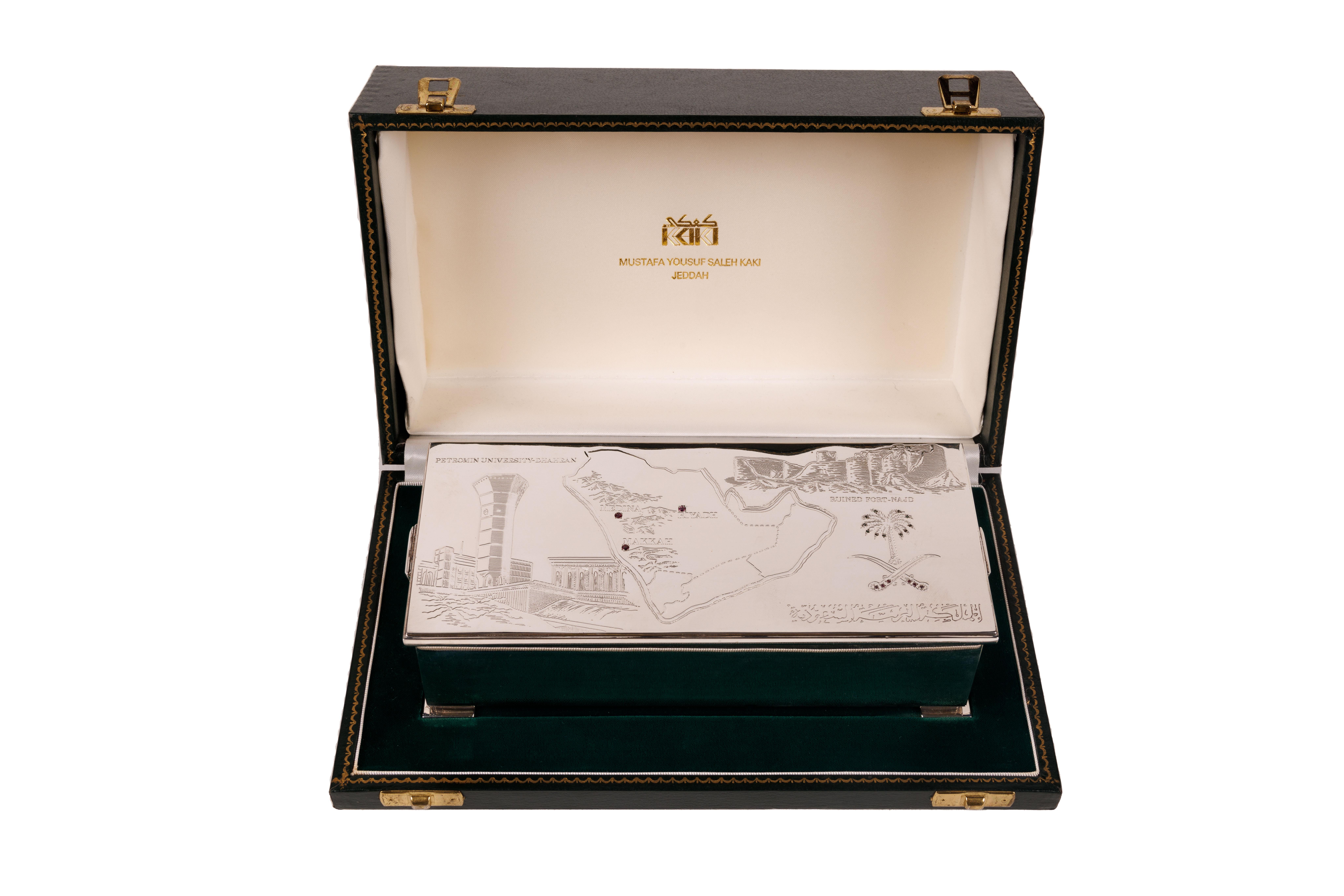 Elizabeth II Sterling Silver and Ruby Humidor Box Made for Saudi Arabia

Made by Peter Nicholas & Co Ltd in London in 1989. Rectangular box with corner bracket supports and hinged open scroll end handles. The top cover is engraved with map of