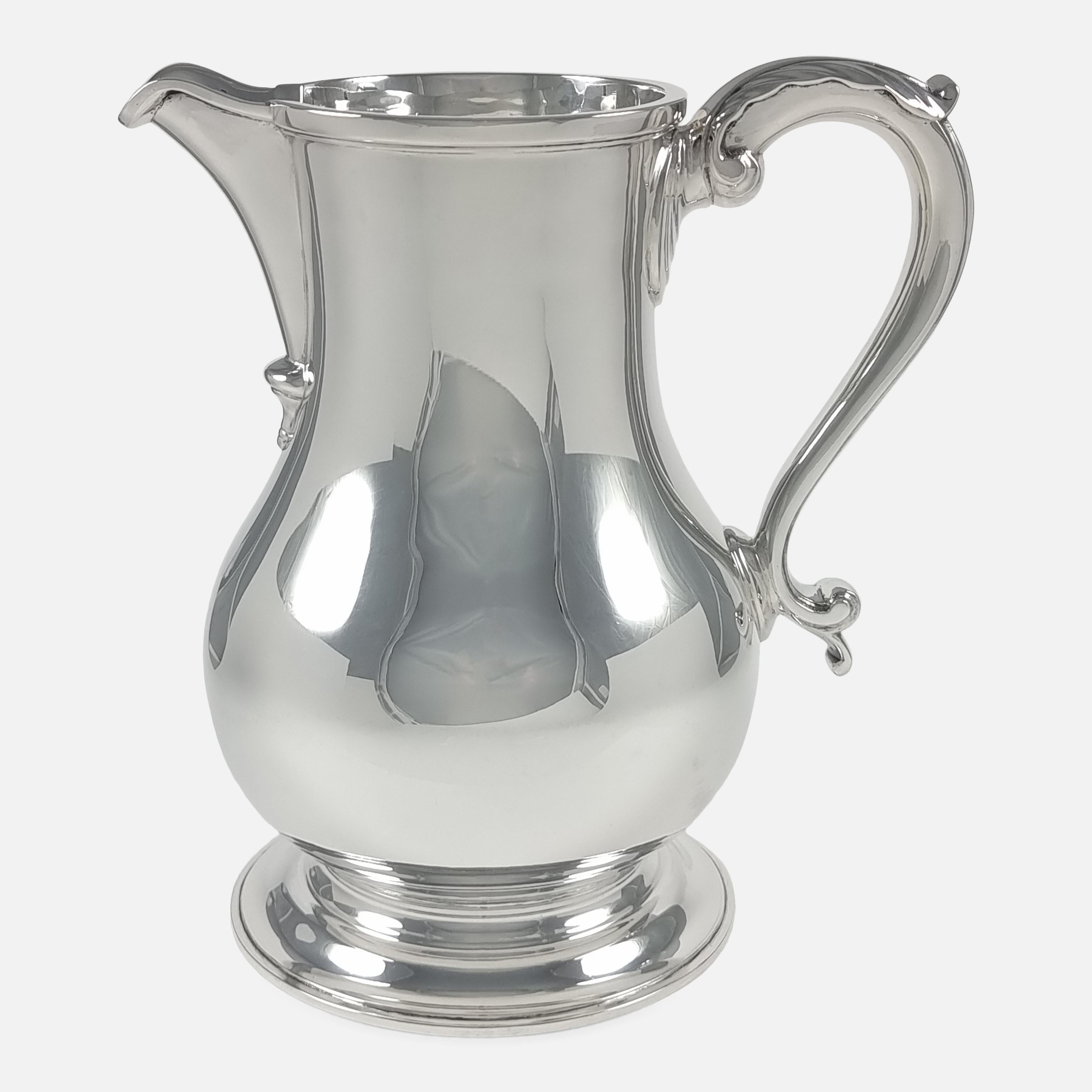 An Elizabeth II sterling silver beer jug or water pitcher.

The jug is crafted in the George III style, of baluster form upon a spreading circular foot, with an acanthus capped scroll handle.

Assay: - .925 Sterling Silver.

Period: - Late 20th